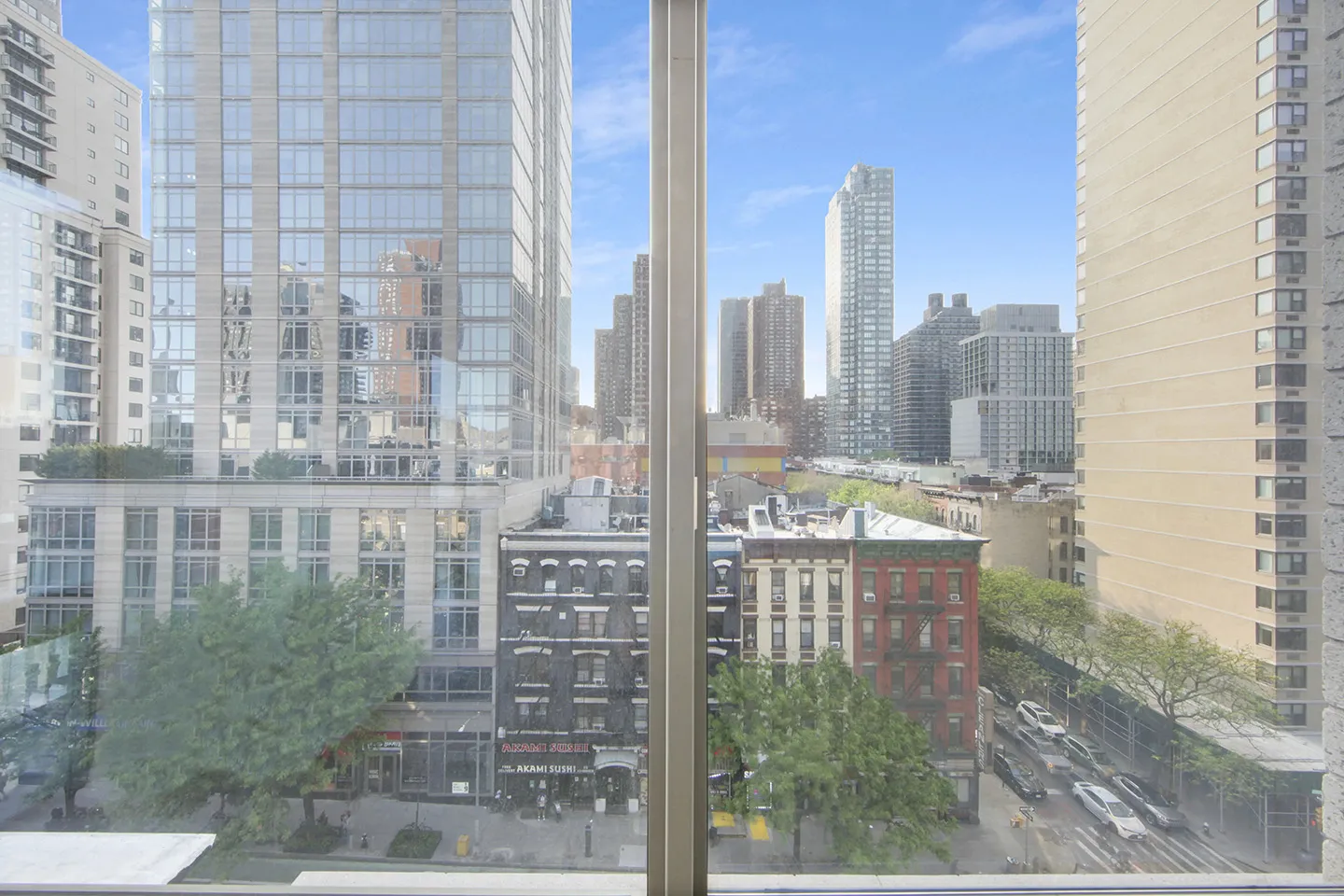 A panoramic view of the city skyline from a high-rise building window, showcasing tall buildings and urban landscape.