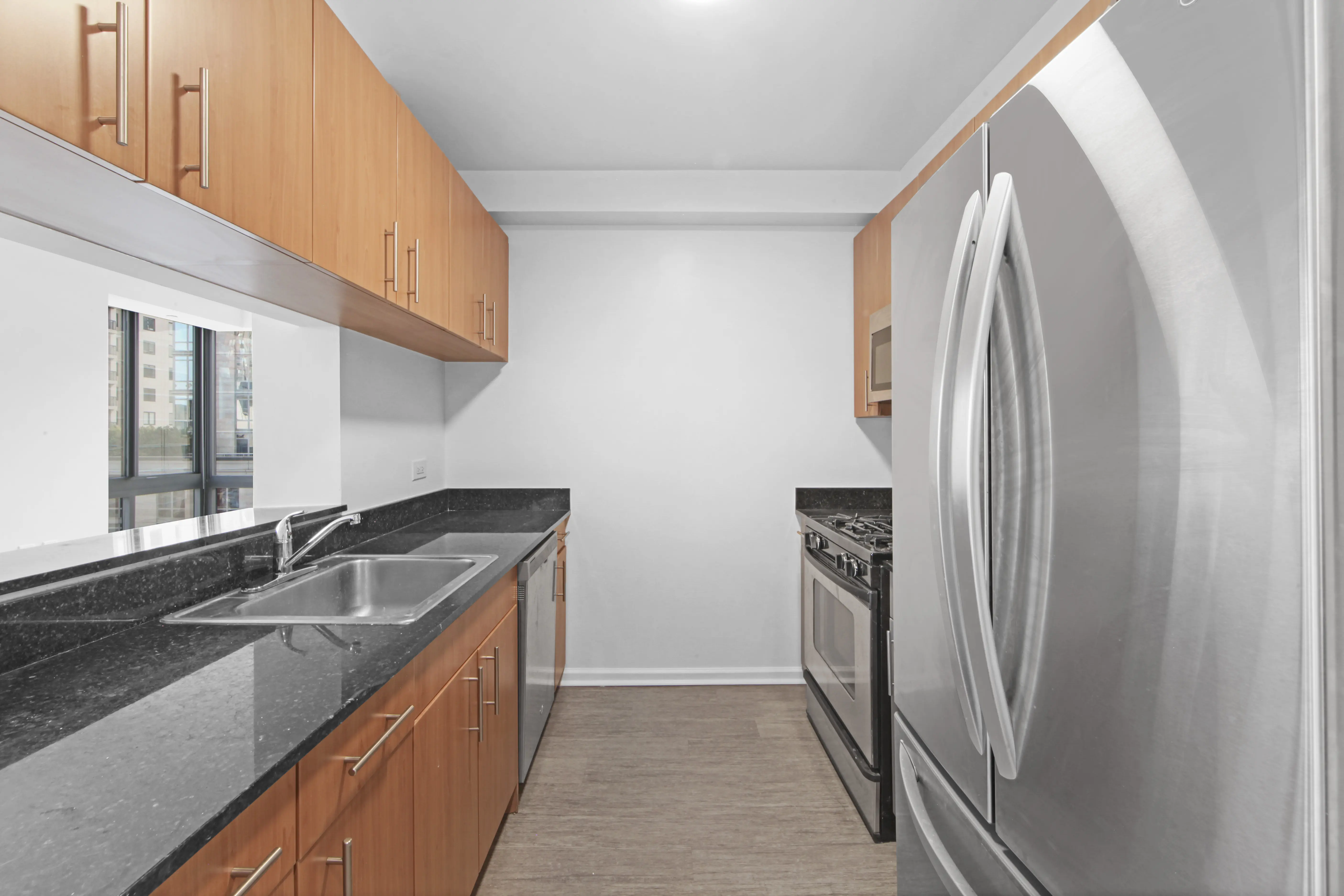 A modern kitchen featuring stainless steel appliances and sleek black countertops.