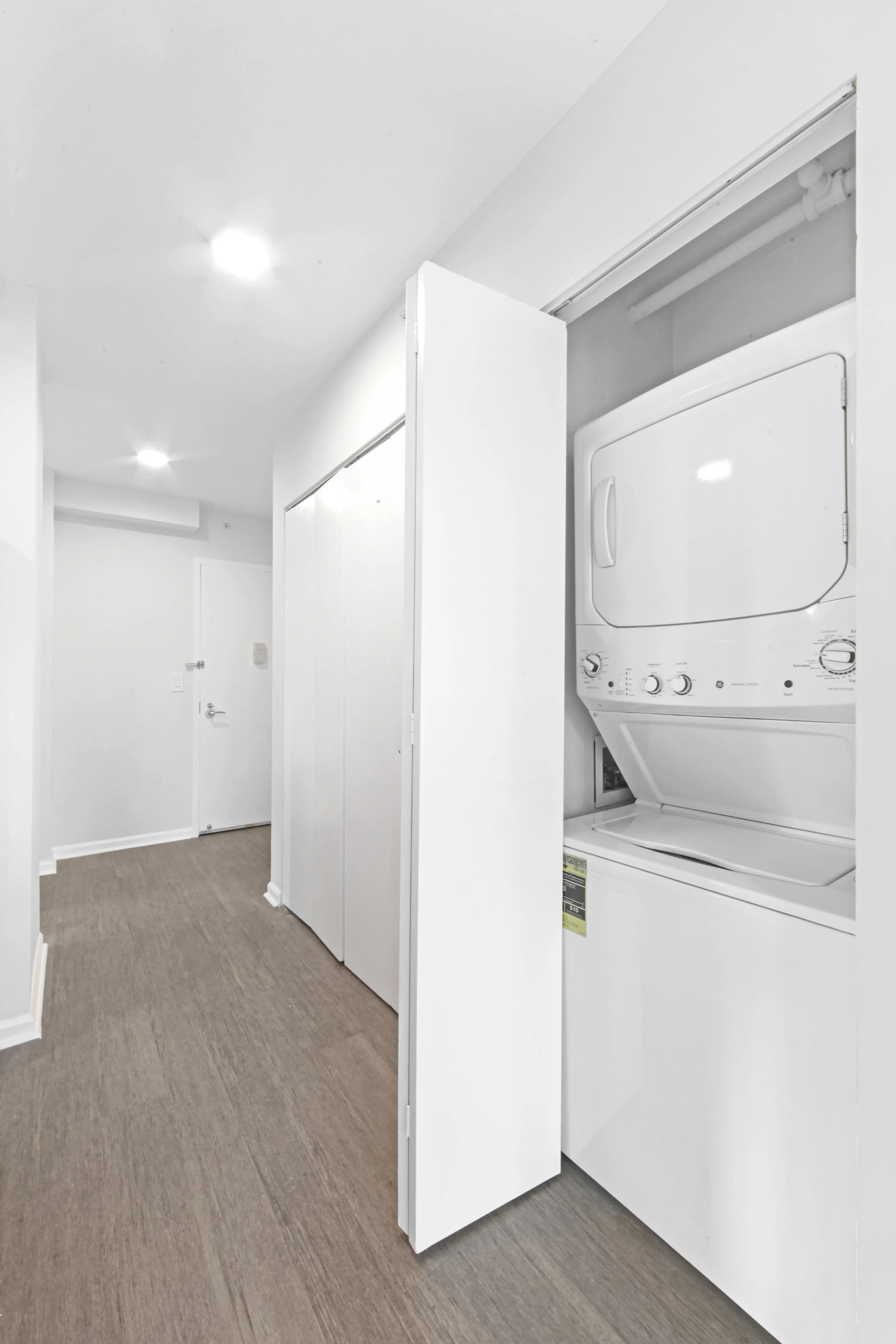 A white washing machine and dryer are located in a hallway, providing laundry facilities in a compact space.