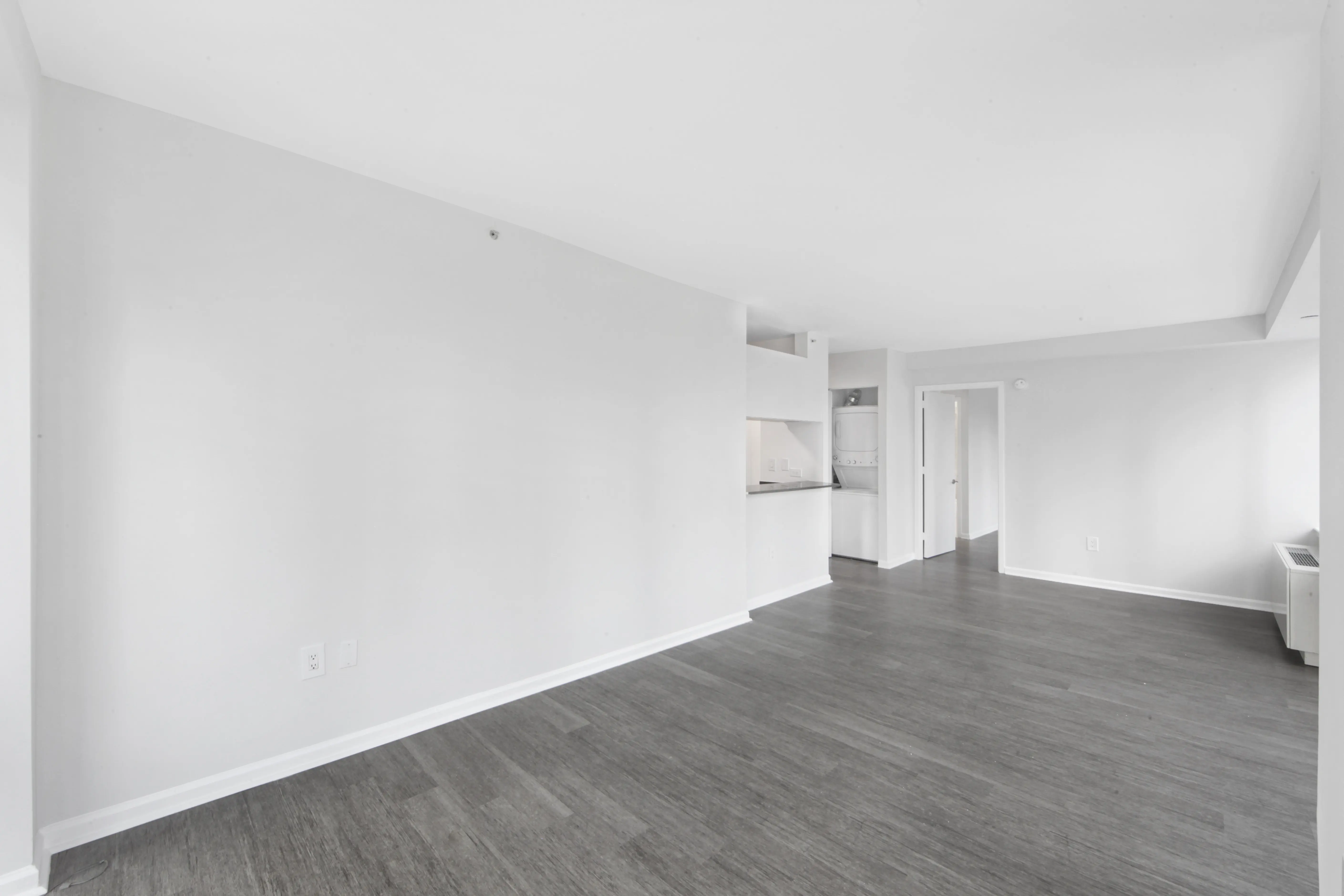 An empty room featuring hardwood floors and white walls, creating a bright and spacious atmosphere.