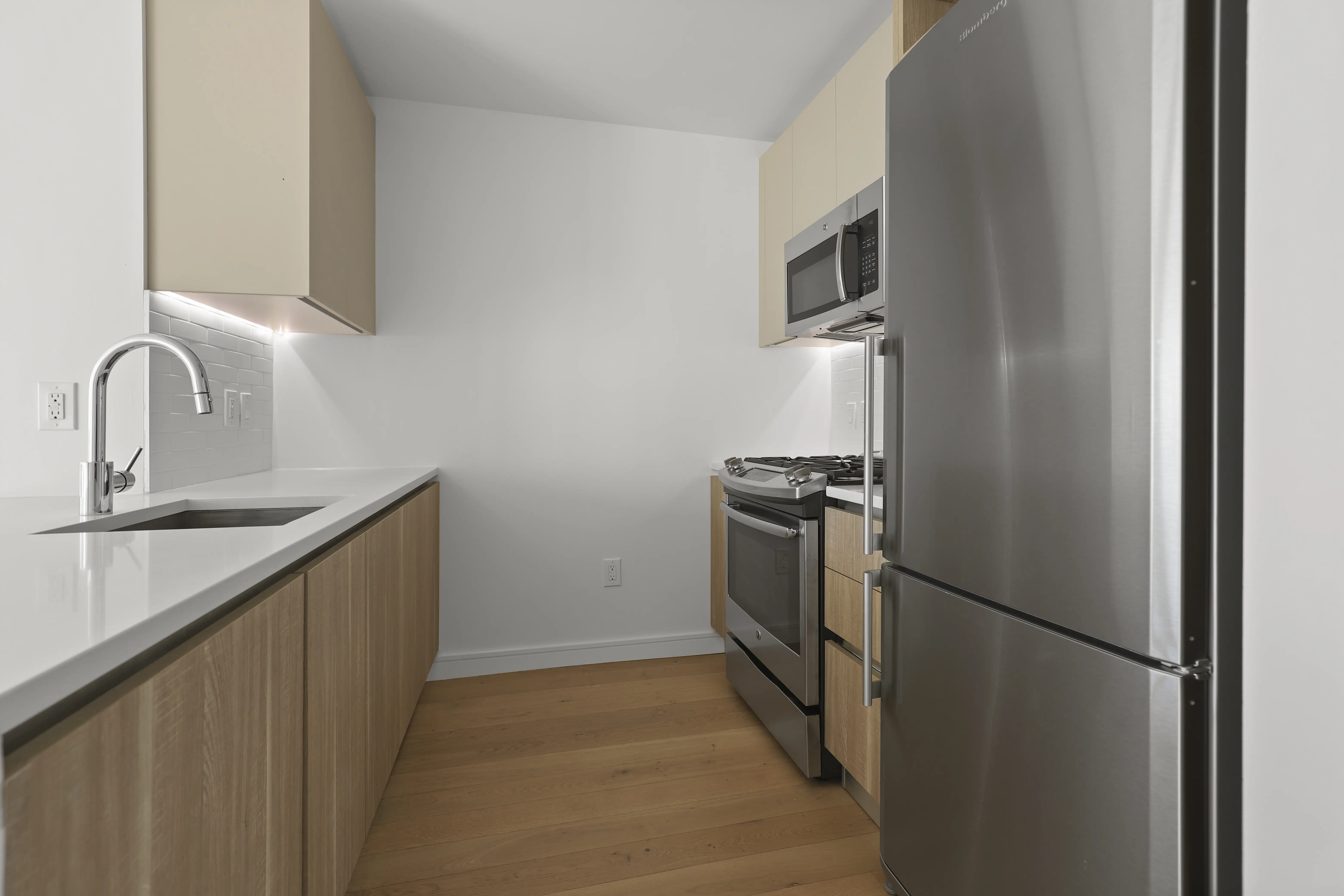 A modern kitchen featuring stainless steel appliances and elegant wooden cabinets.