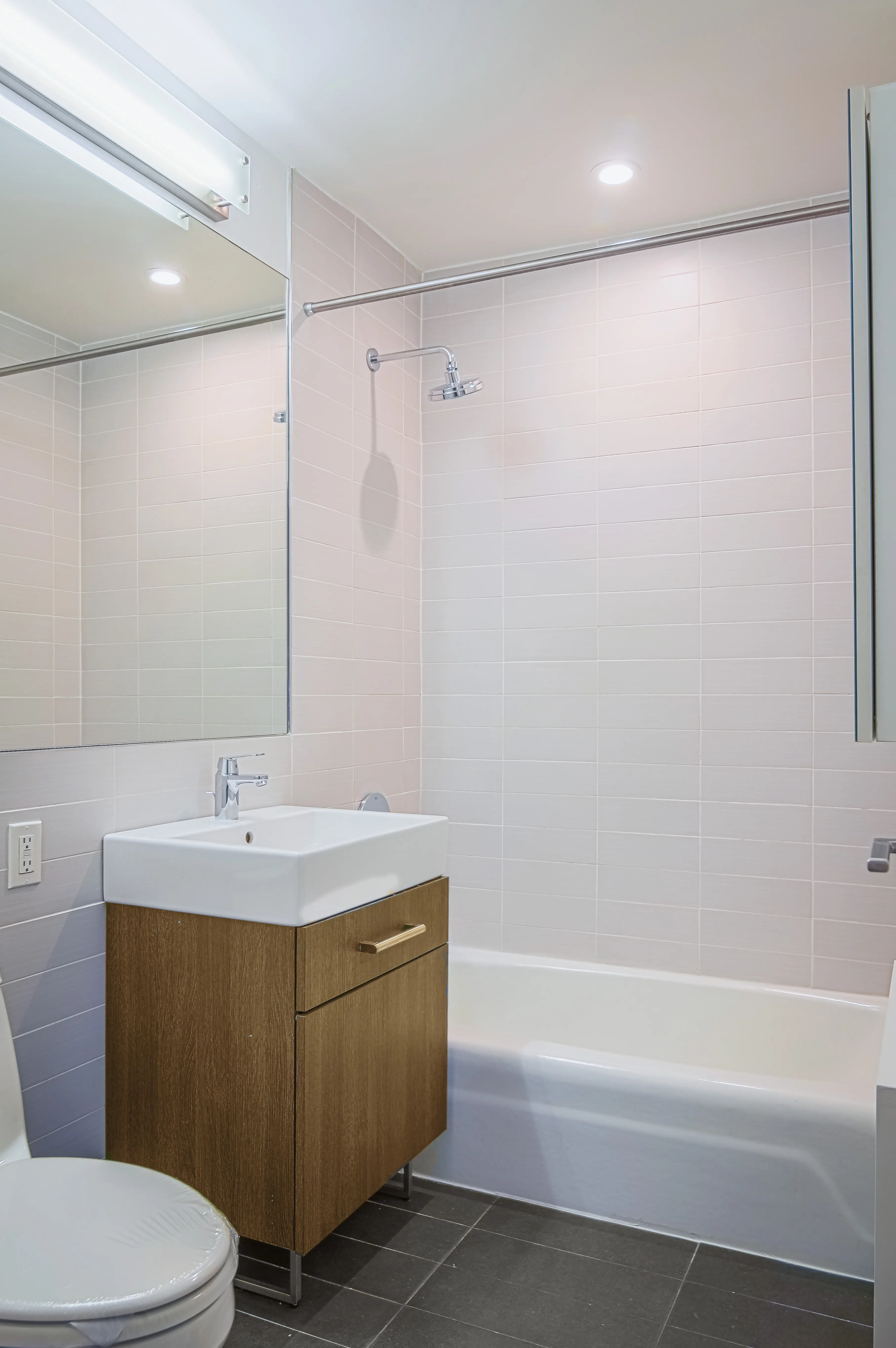 A bathroom featuring a toilet, sink, and bathtub arranged in a clean and modern layout.