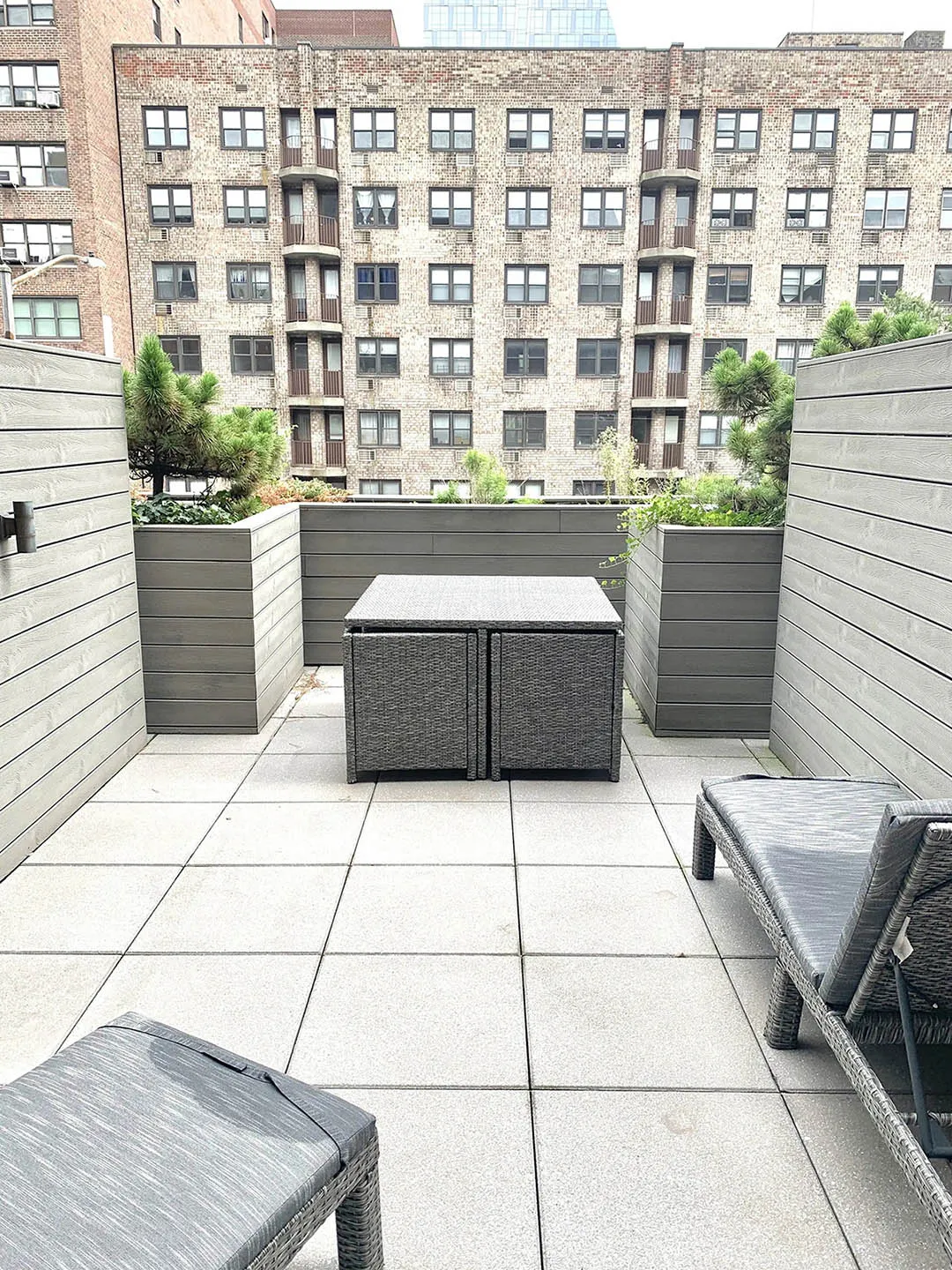 A patio featuring two lounge chairs and a small table, ideal for relaxation and outdoor gatherings.