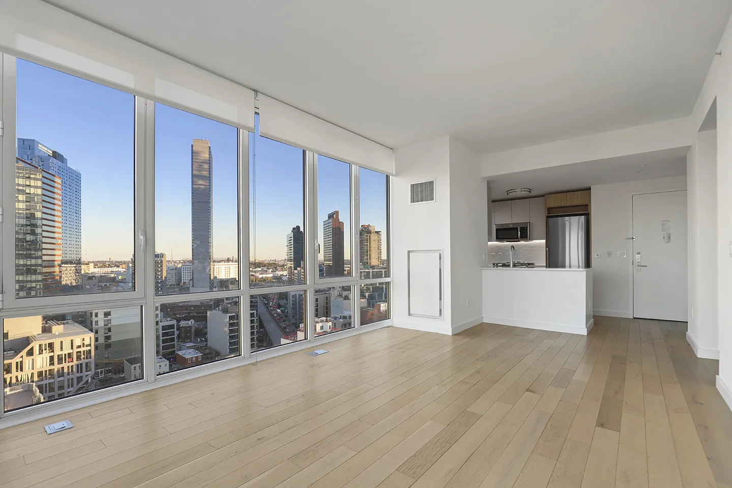 A spacious room featuring hardwood floors and large windows that allow ample natural light.