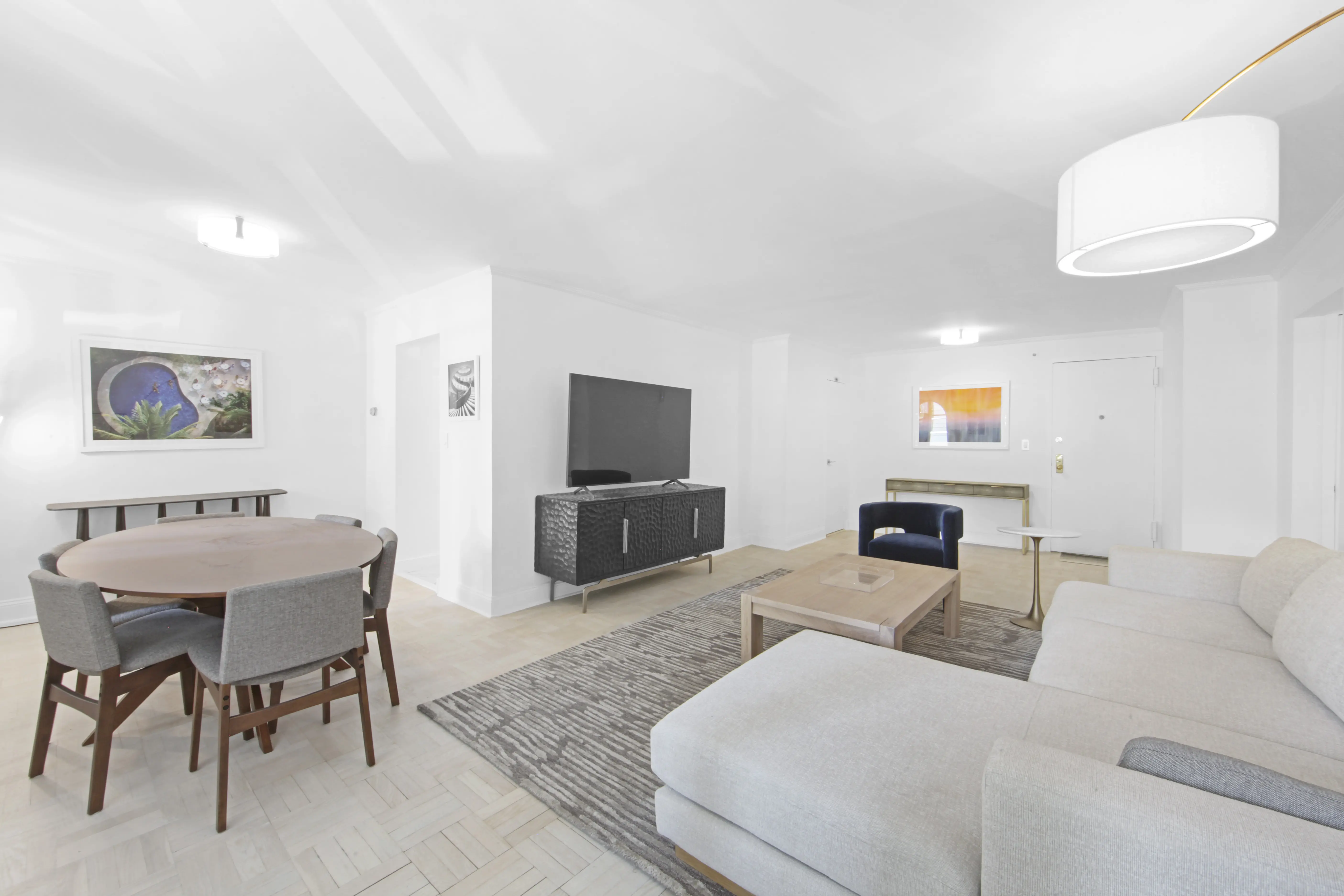 A clean and organized living room with a comfortable couch, a table, and a television for entertainment.