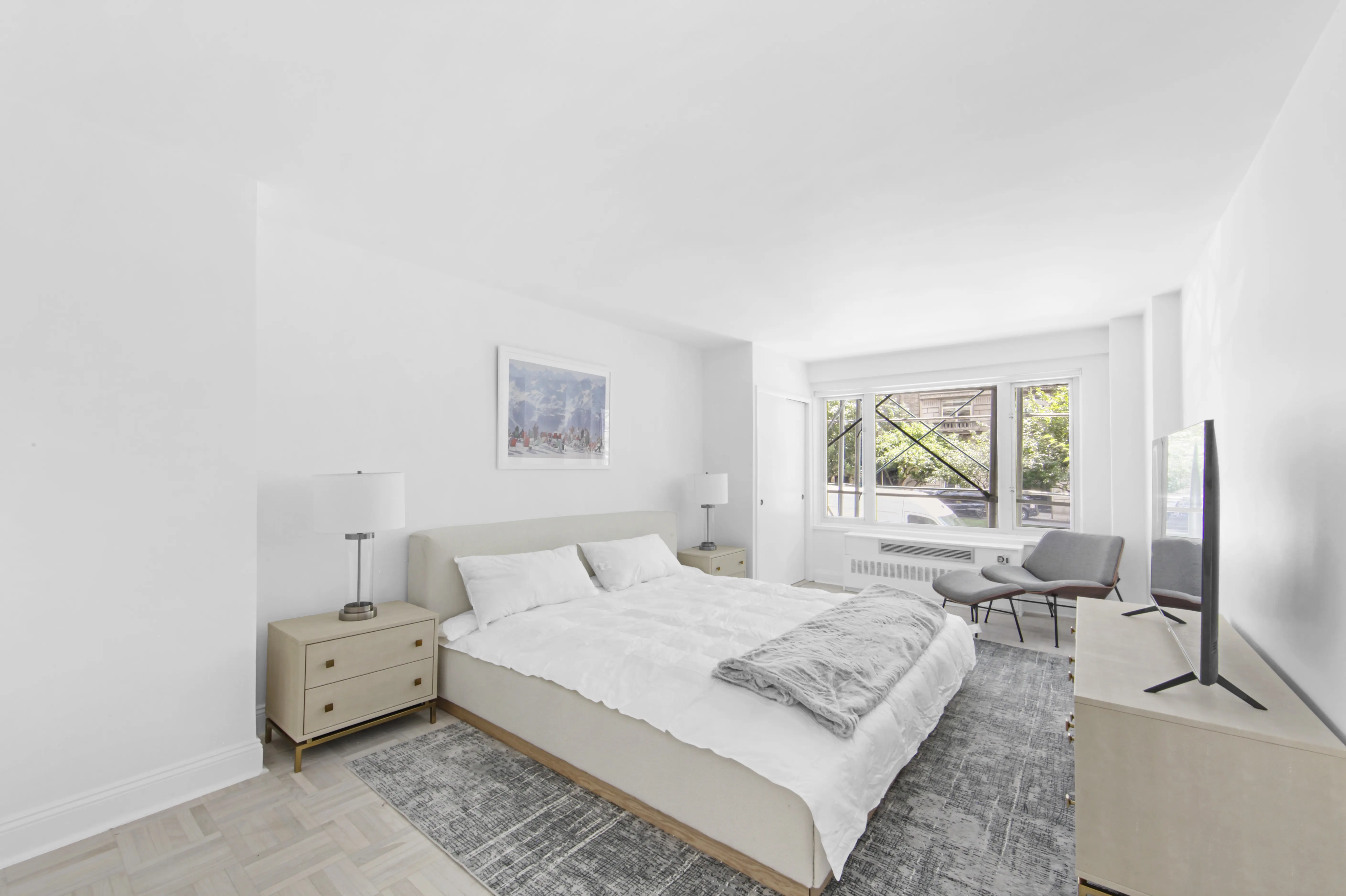A minimalist bedroom showcasing white walls and a comfortable bed, emphasizing a calm and peaceful environment.