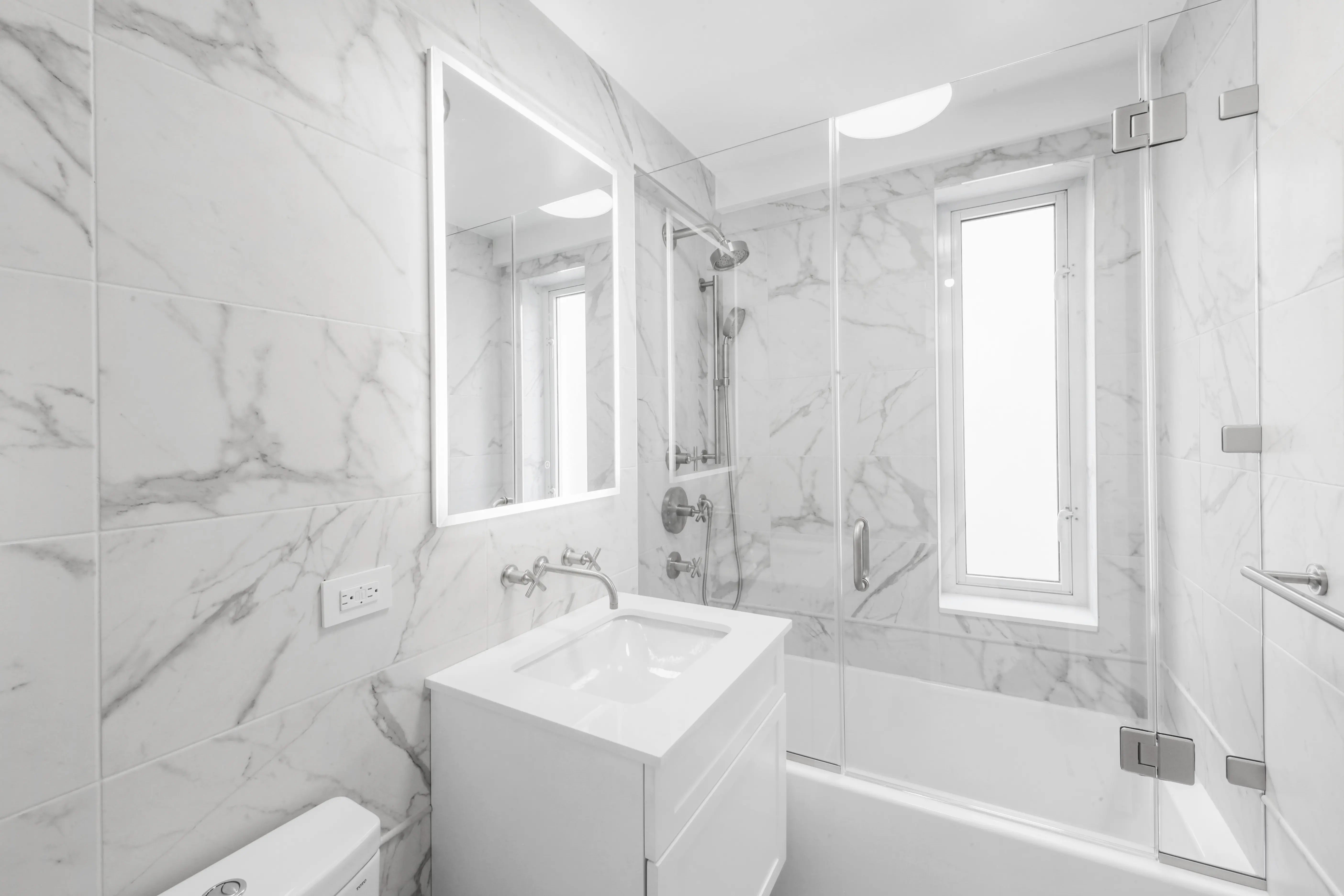 A luxurious bathroom featuring elegant marble walls and flooring, creating a sophisticated and modern atmosphere.
