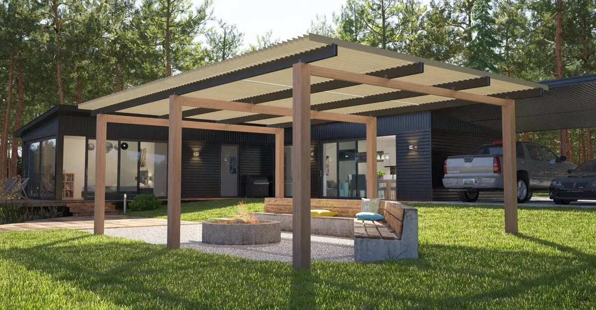 Modern house with wooden pergola, fire pit, and seating area on grassy lawn with cars parked.