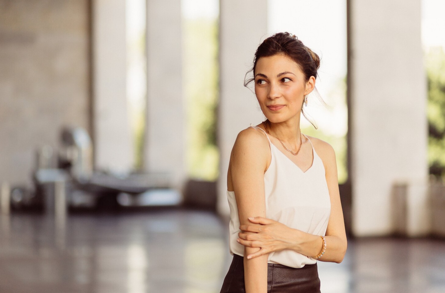 A slim and fit woman looking sideways and subtly smiling
