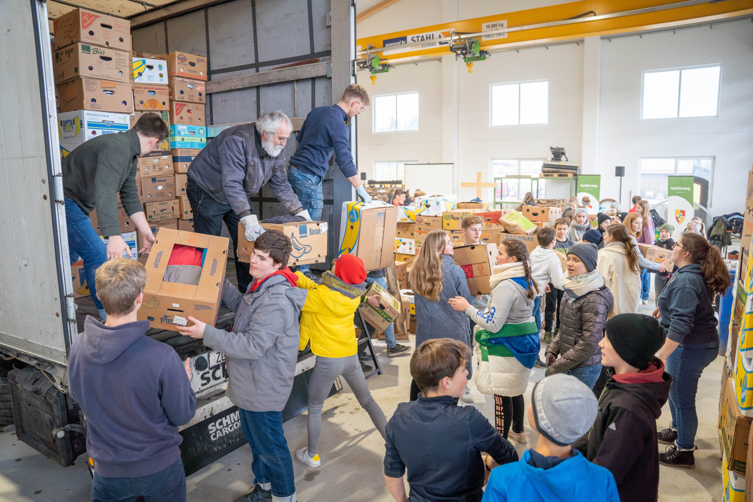 Helfer bei einer JLH-Sammelaktion mit zahlreichen gepackten Hilfsgütern