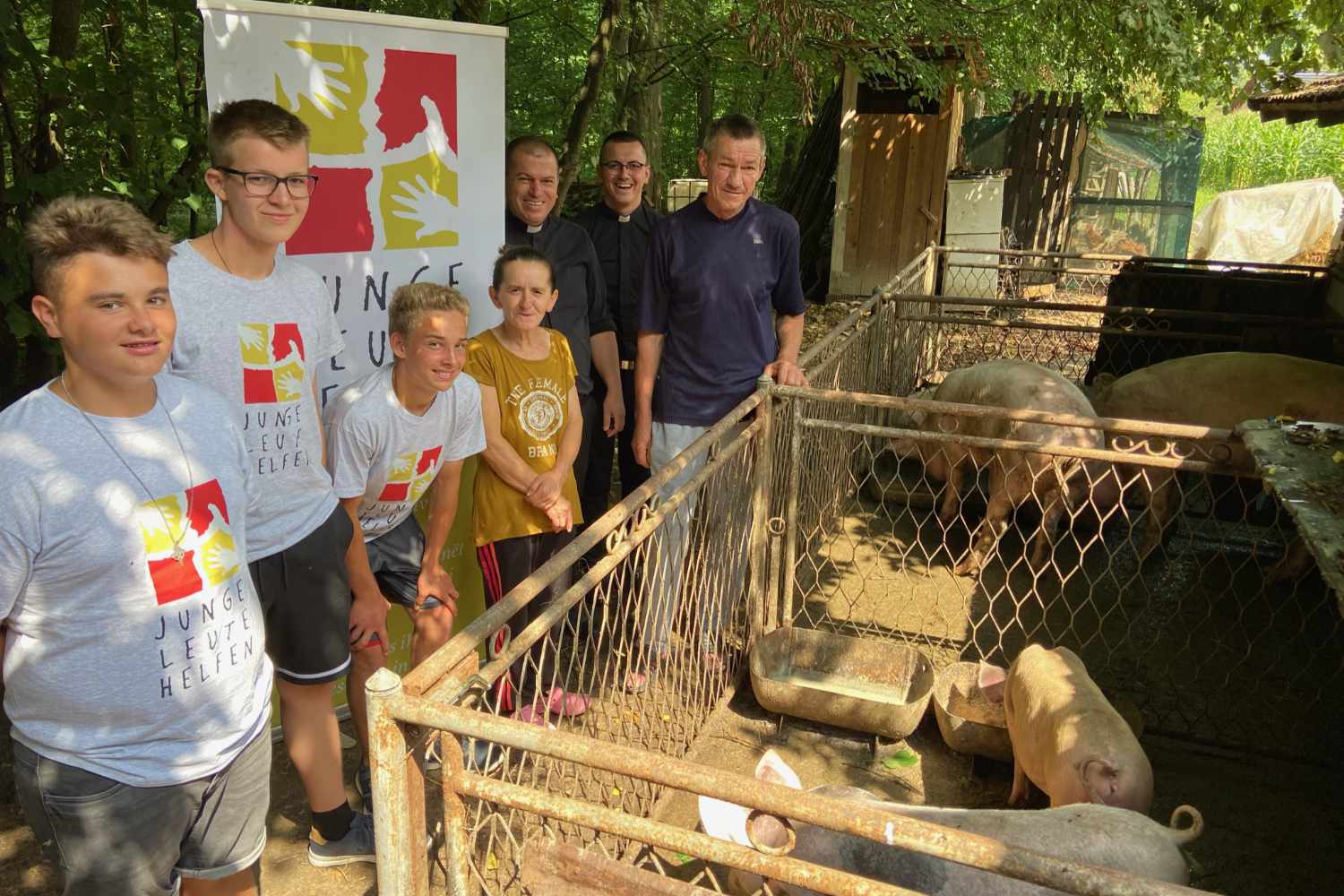 JLH-Helfer bei Schweinen auf einem Hof im Projekt Der gute Hirte