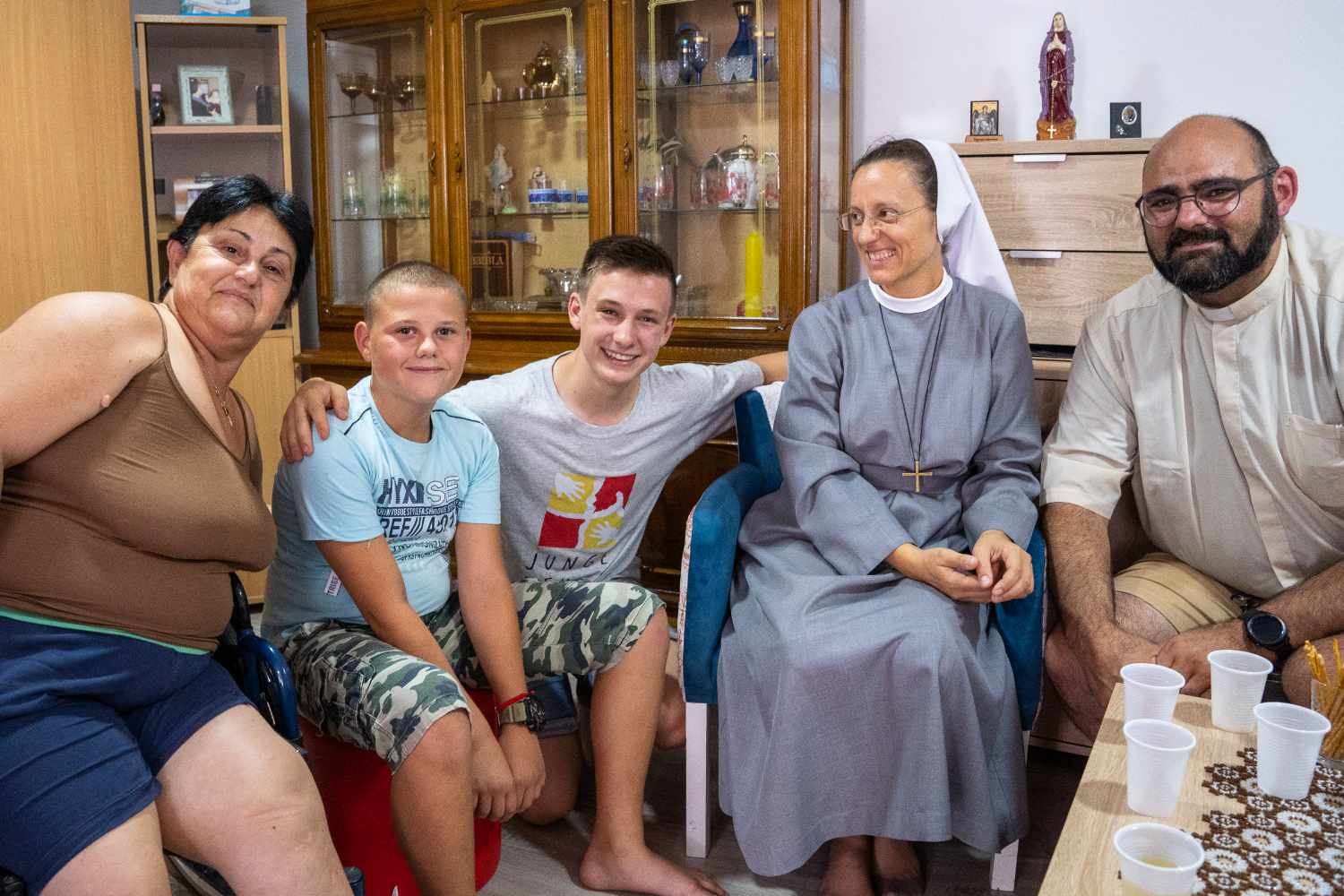 Junge Menschen und Erwachsene sitzen gemeinsam in Gebäude