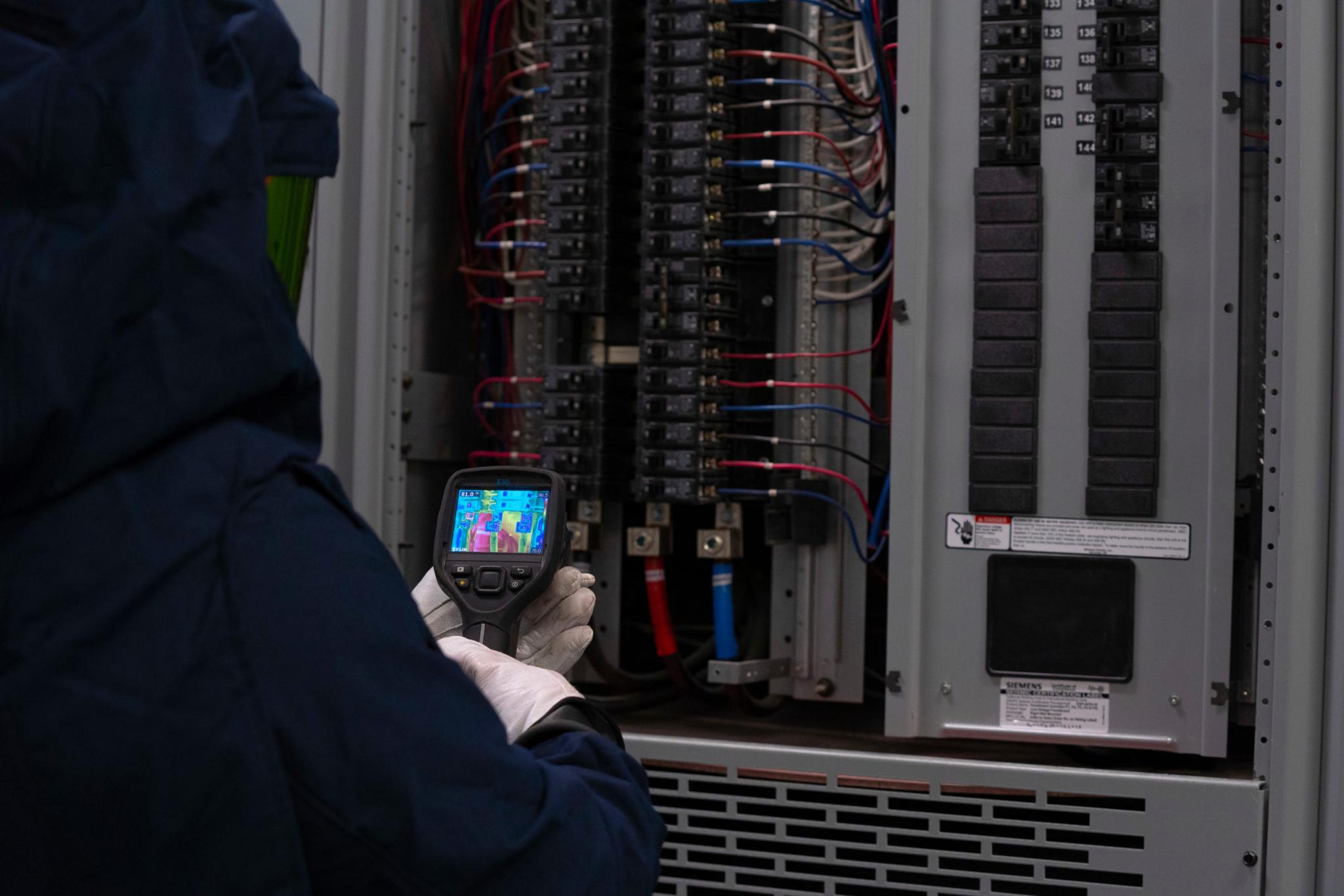 VarcoMac technician performing electrical maintenance on industrial system