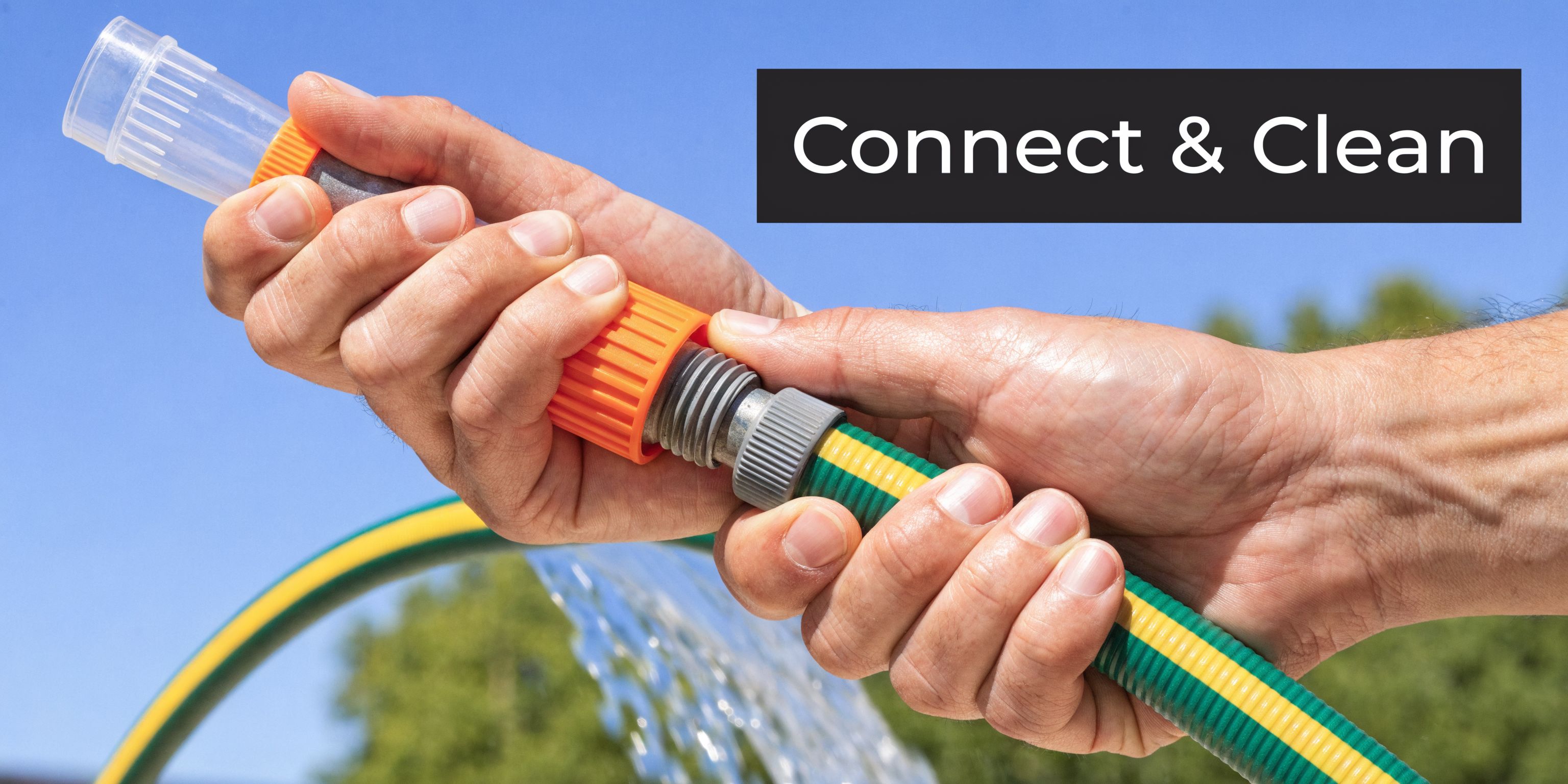 Close-up of hands connecting a green and yellow garden hose with a plastic water spray attachment.