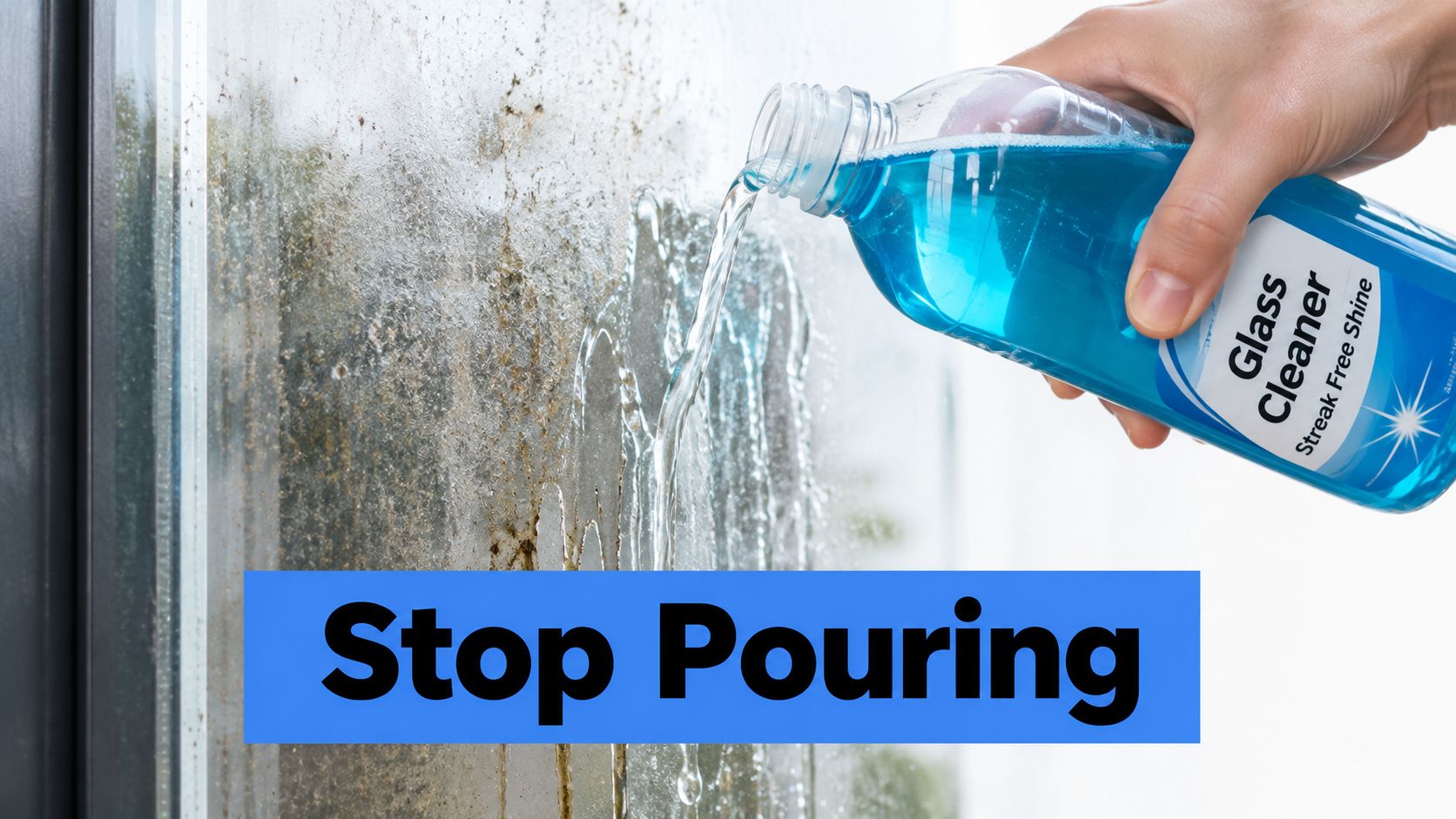 A hand pouring blue glass cleaner liquid directly onto a dirty windowpane for cleaning purposes.