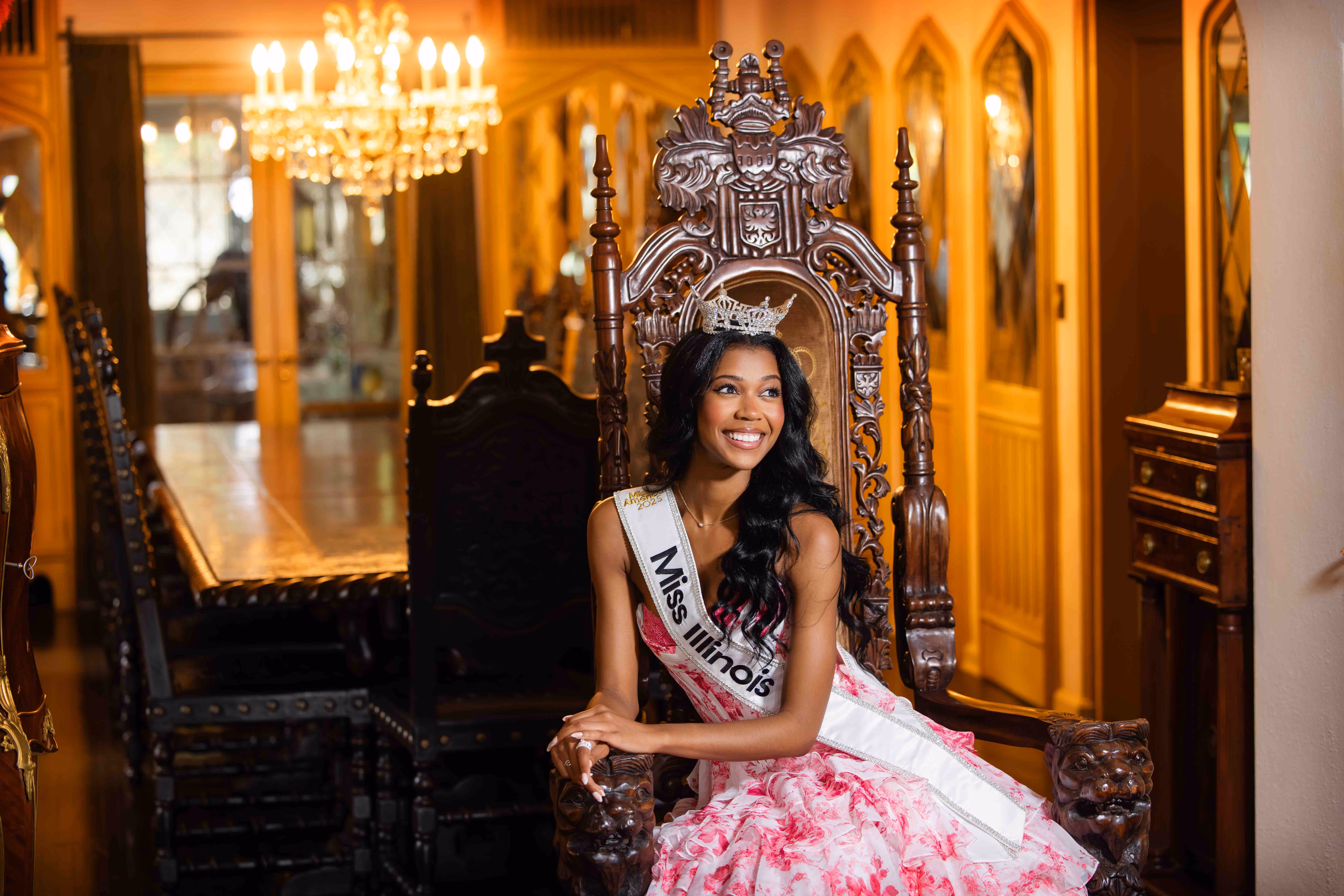Miss Illinois 2025 sits in a wing back chair in the dining room of the Soderstrom Castle while wearing her crown, sash, and pageant dress.