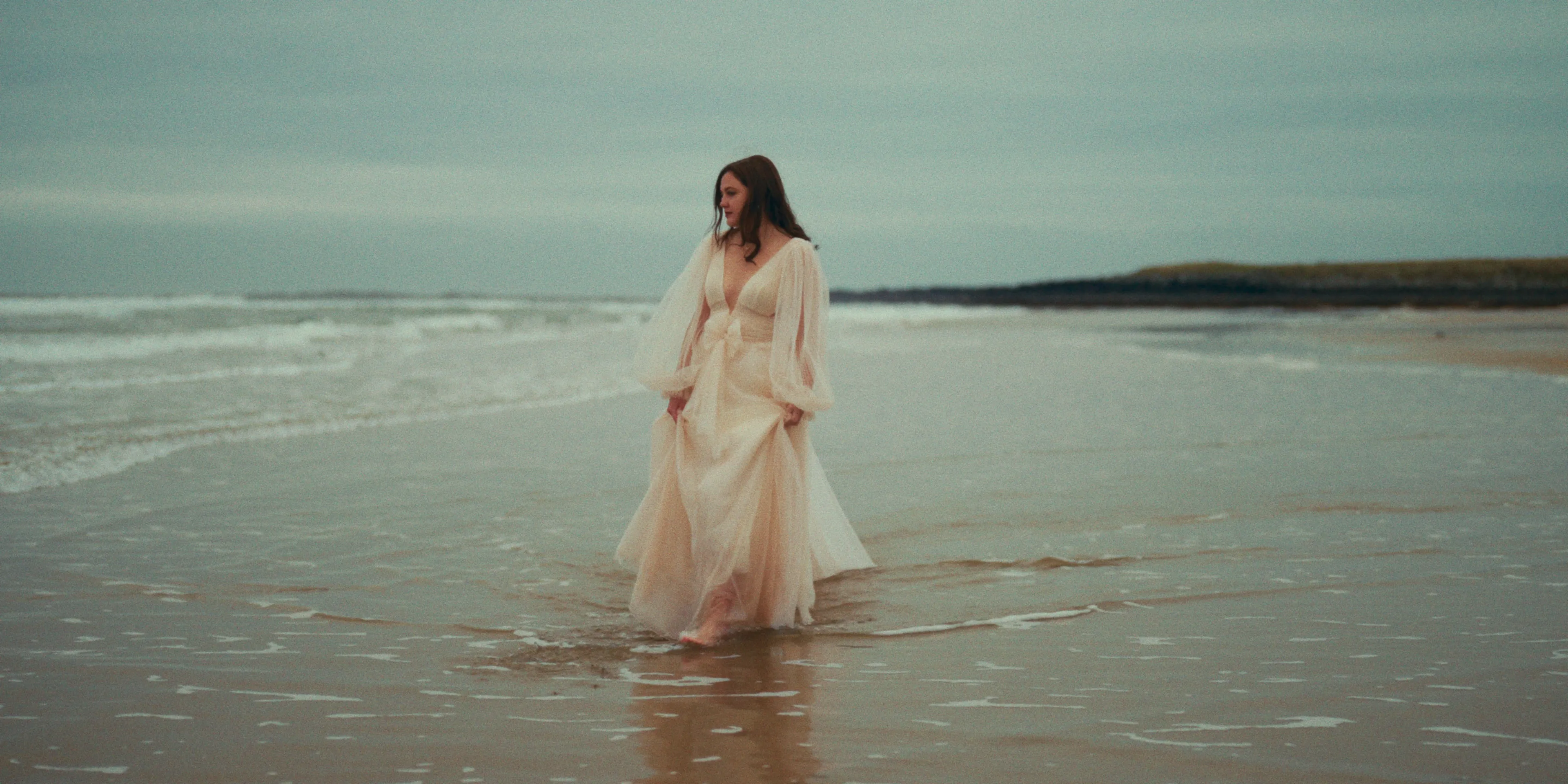 Bride walking barefoot on a beach
