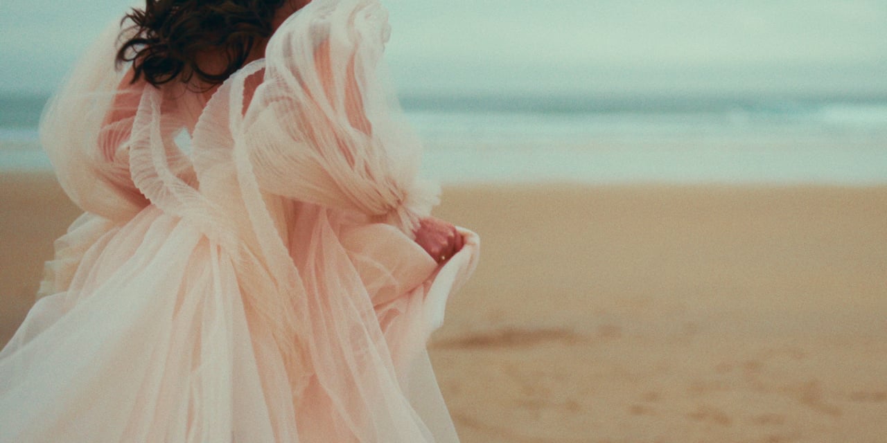 A bride’s dress in the wind on a beach in Northumberland
