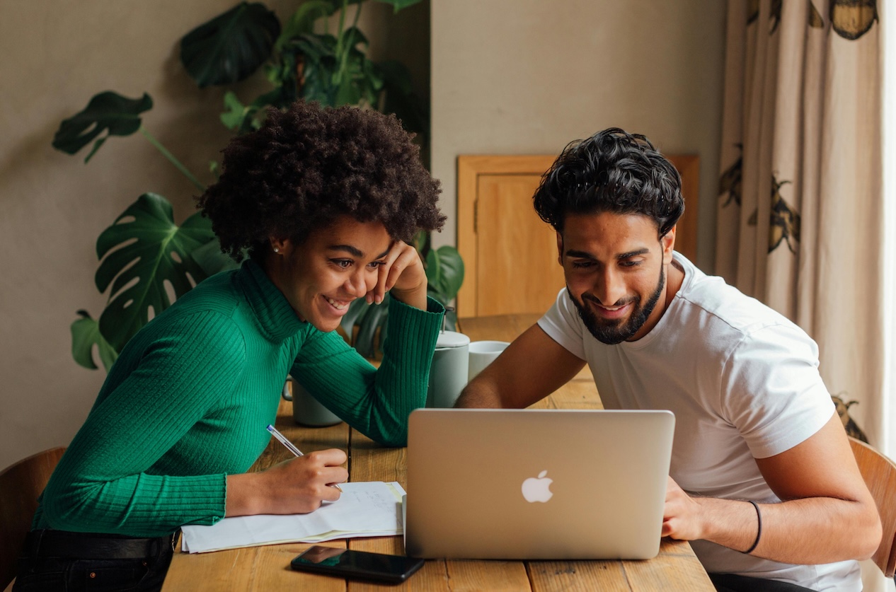 woman and man looking at investments on laptop
