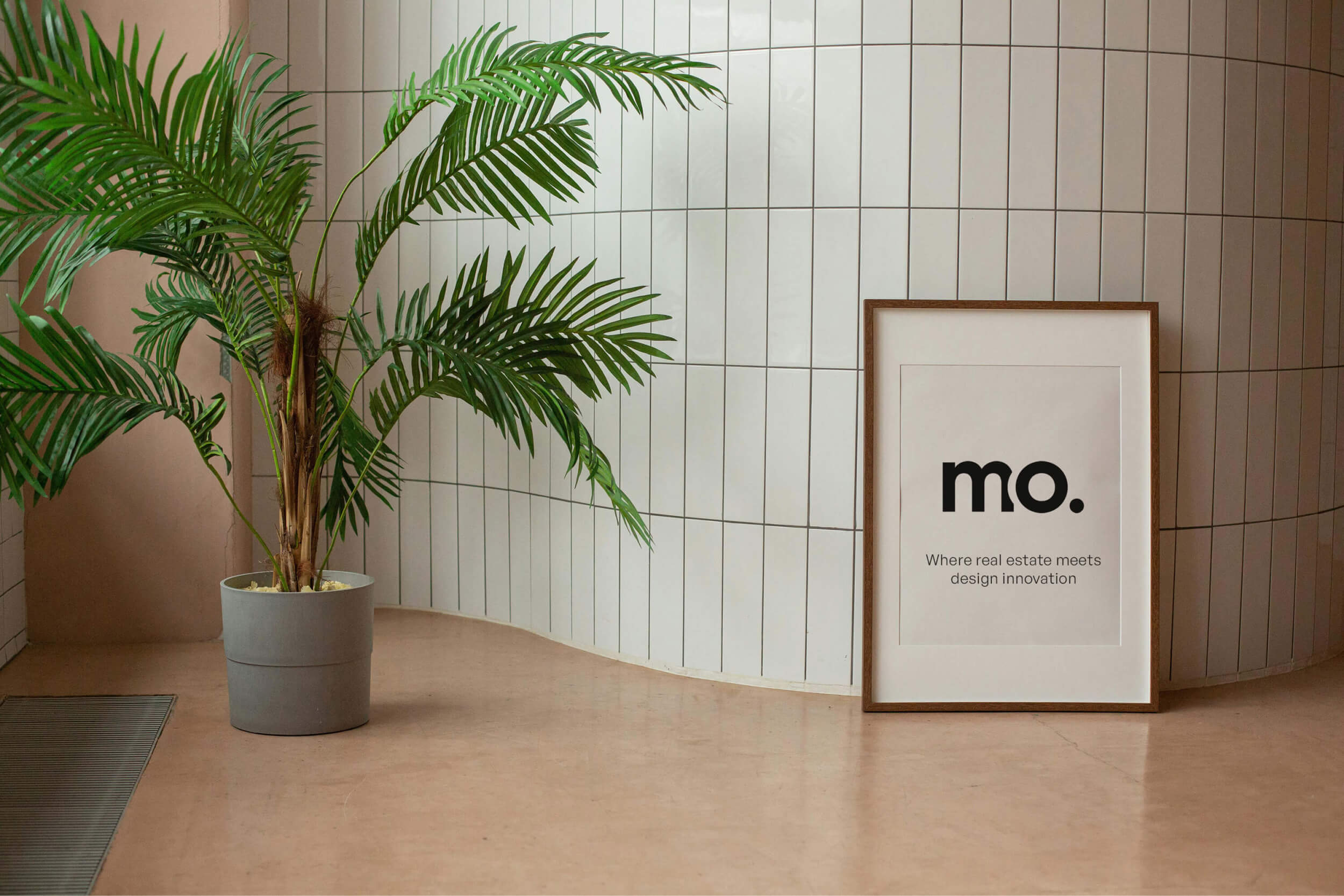 a picture frame with the logo of molda leaning against a white wall with tiles