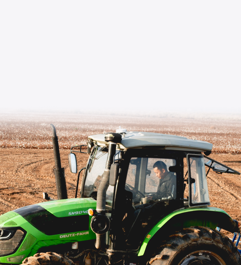 Man hands-free steering a tractor