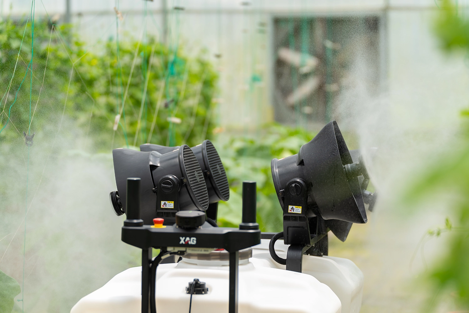 Six-wheeled agricultural robot with white tanks and black equipment on grassy field