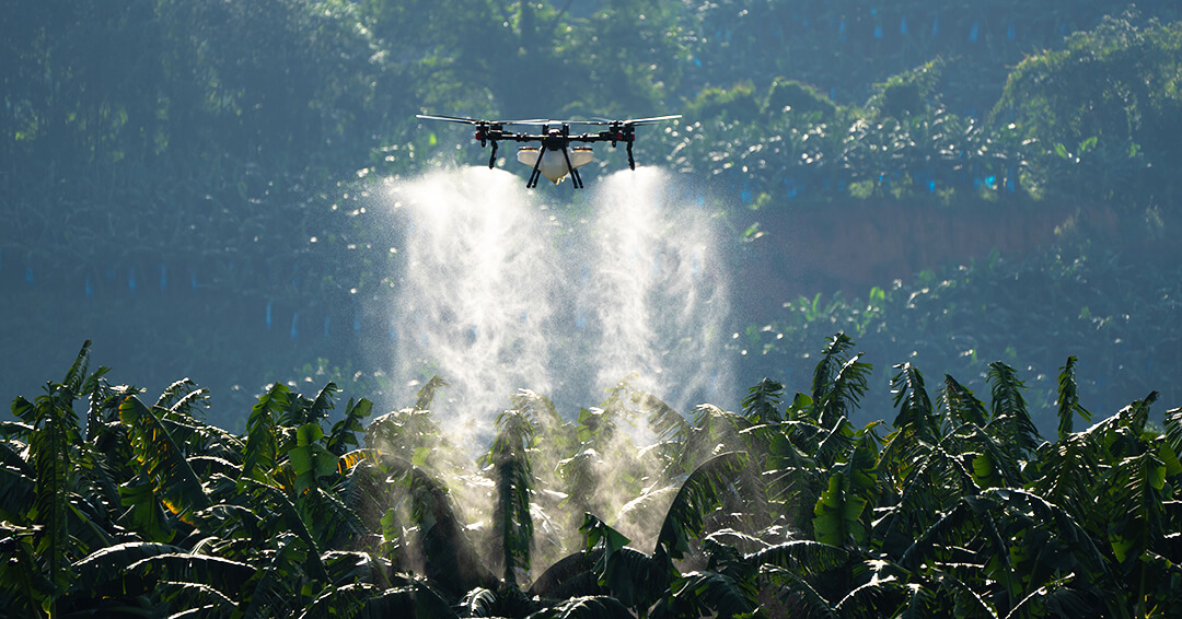 XAG agricultural drone spraying crops over a lush plantation.