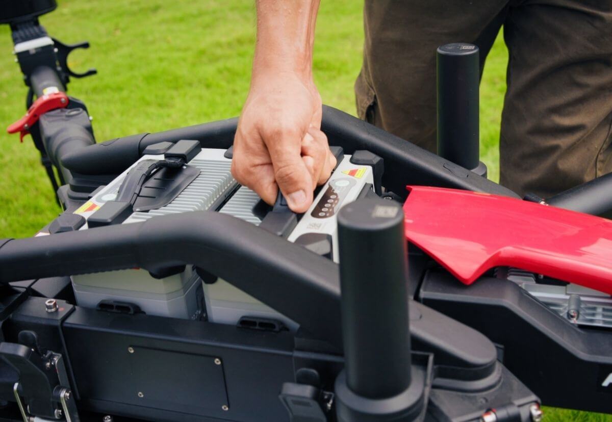 Operator installing a smart battery into the XAG P150 Max agricultural drone.