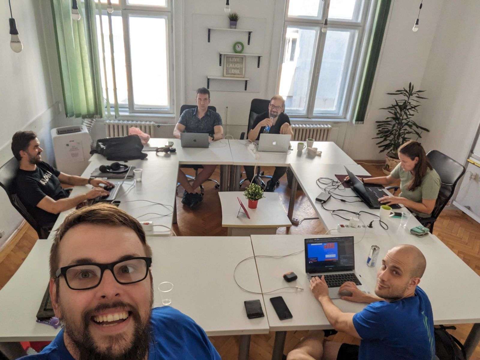 High-angle shot of the full FWRD Digital team working together around a large desk in a professional agency setting.