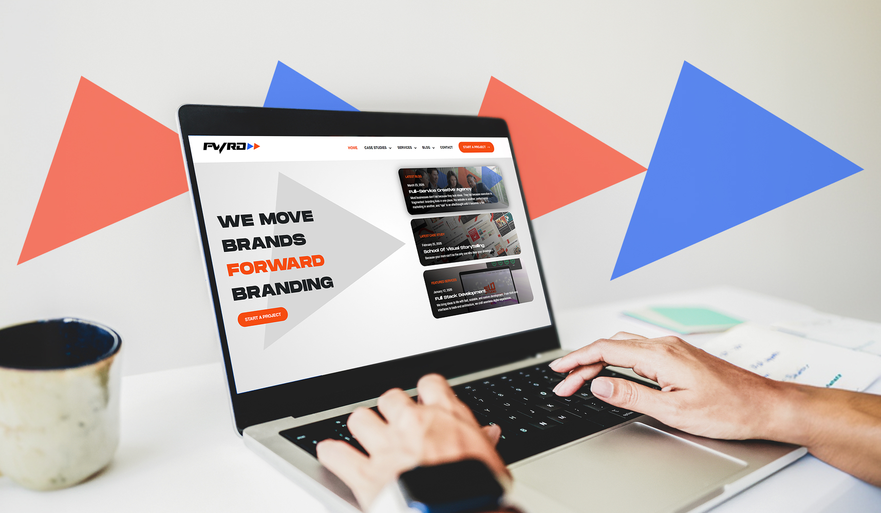 Hands on laptop viewing a creative agency homepage with a call to action for brand and website redesign services.