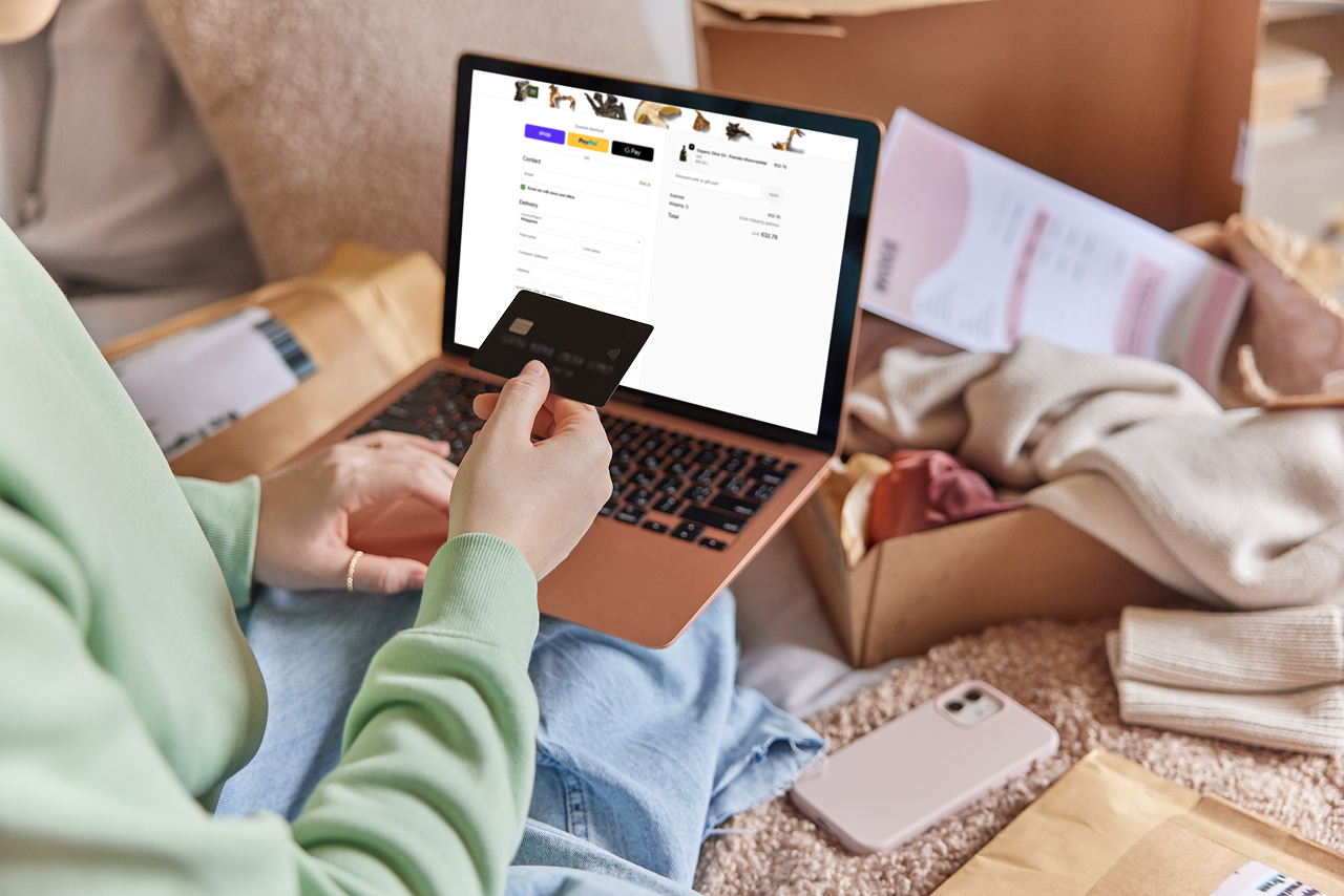 Customer shopping for fashion bundles on a resale ecommerce website while holding a credit card, surrounded by clothing packages.