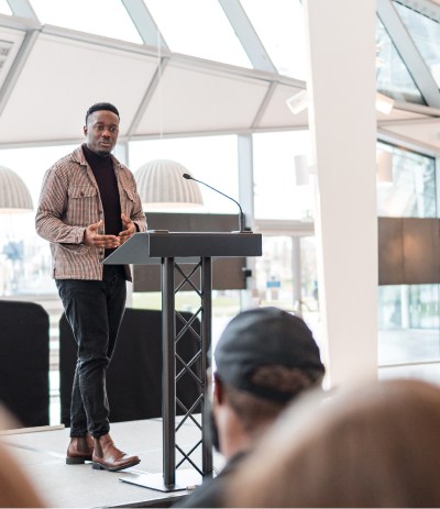 Man presenting to a room filled with people