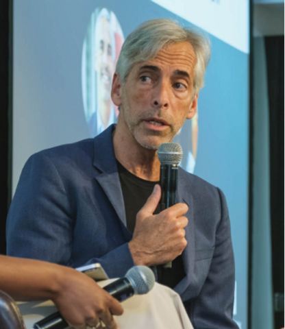 Man on stage with microphone speaking