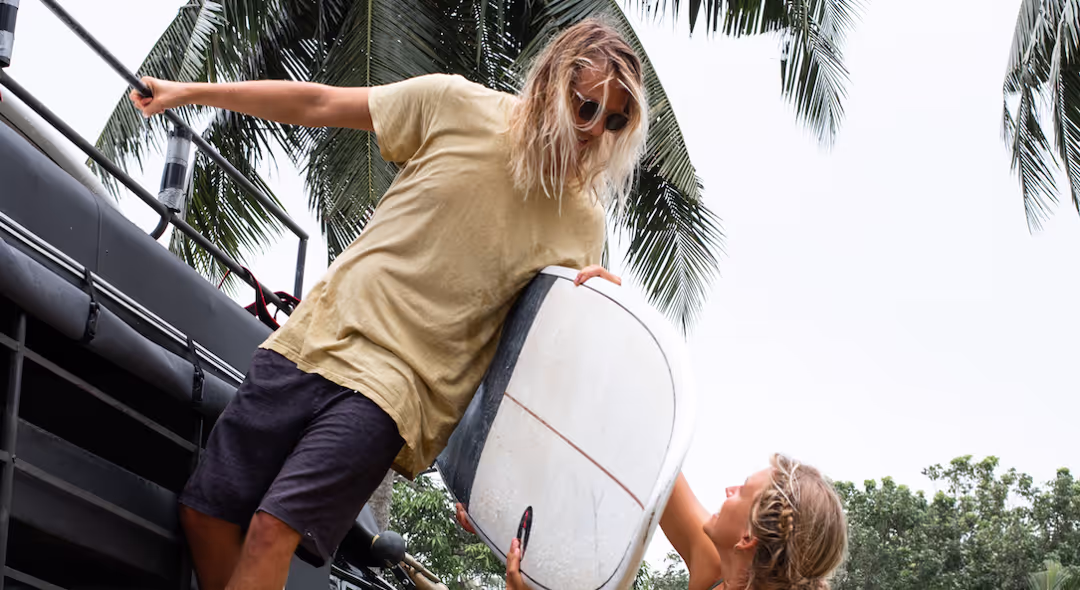 A man holding a surfboard with a woman standing next to him.