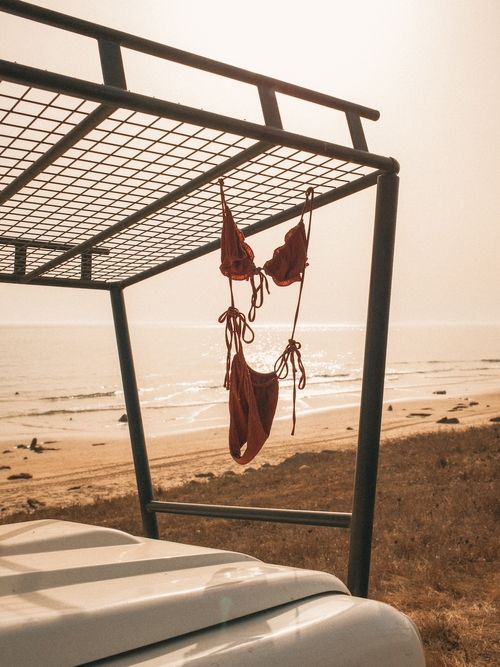 A pair of red bikinis hanging on a metal rack.