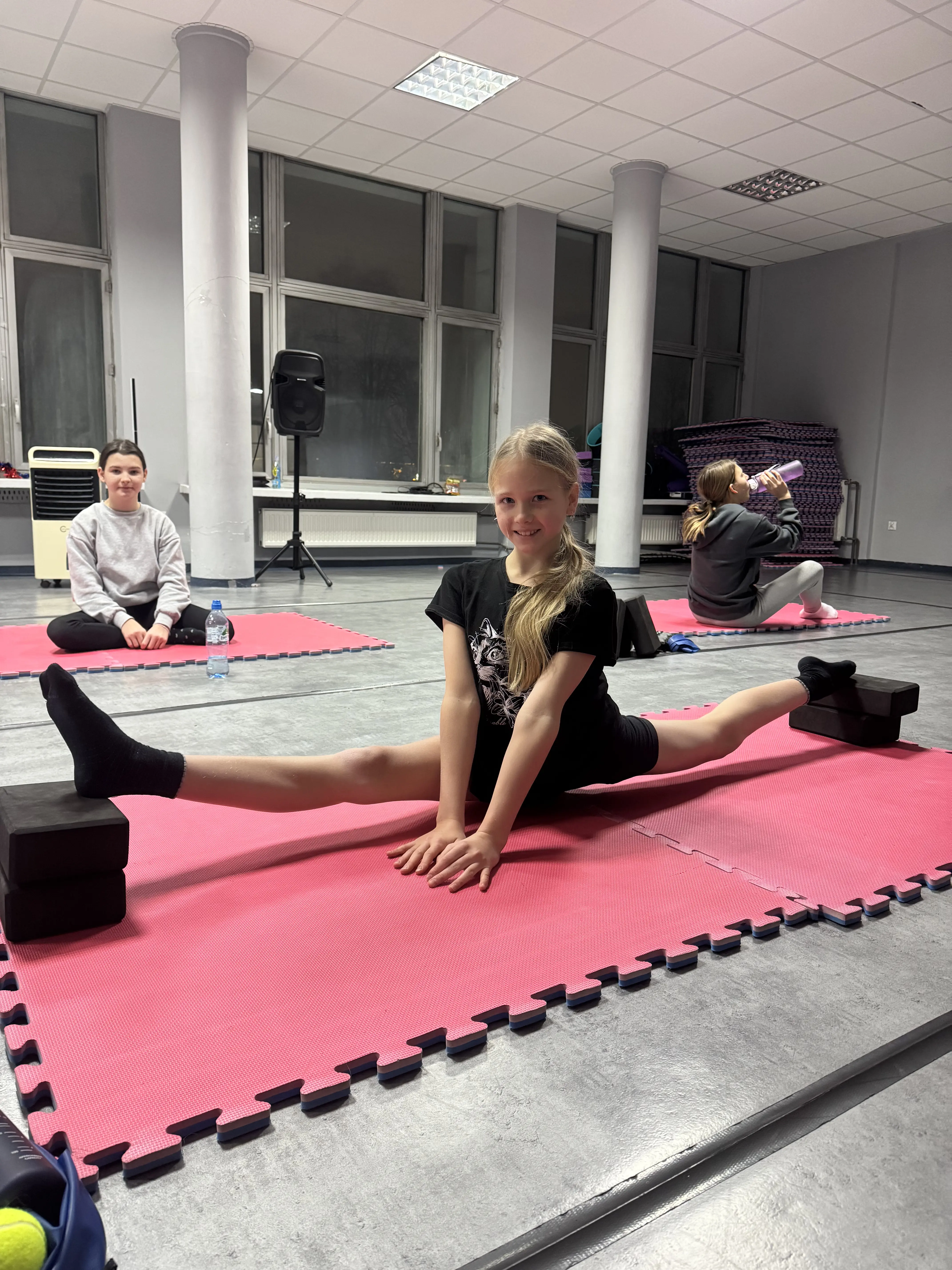 Dziewczynka wykonująca szpagat podczas zajęć stretchingu