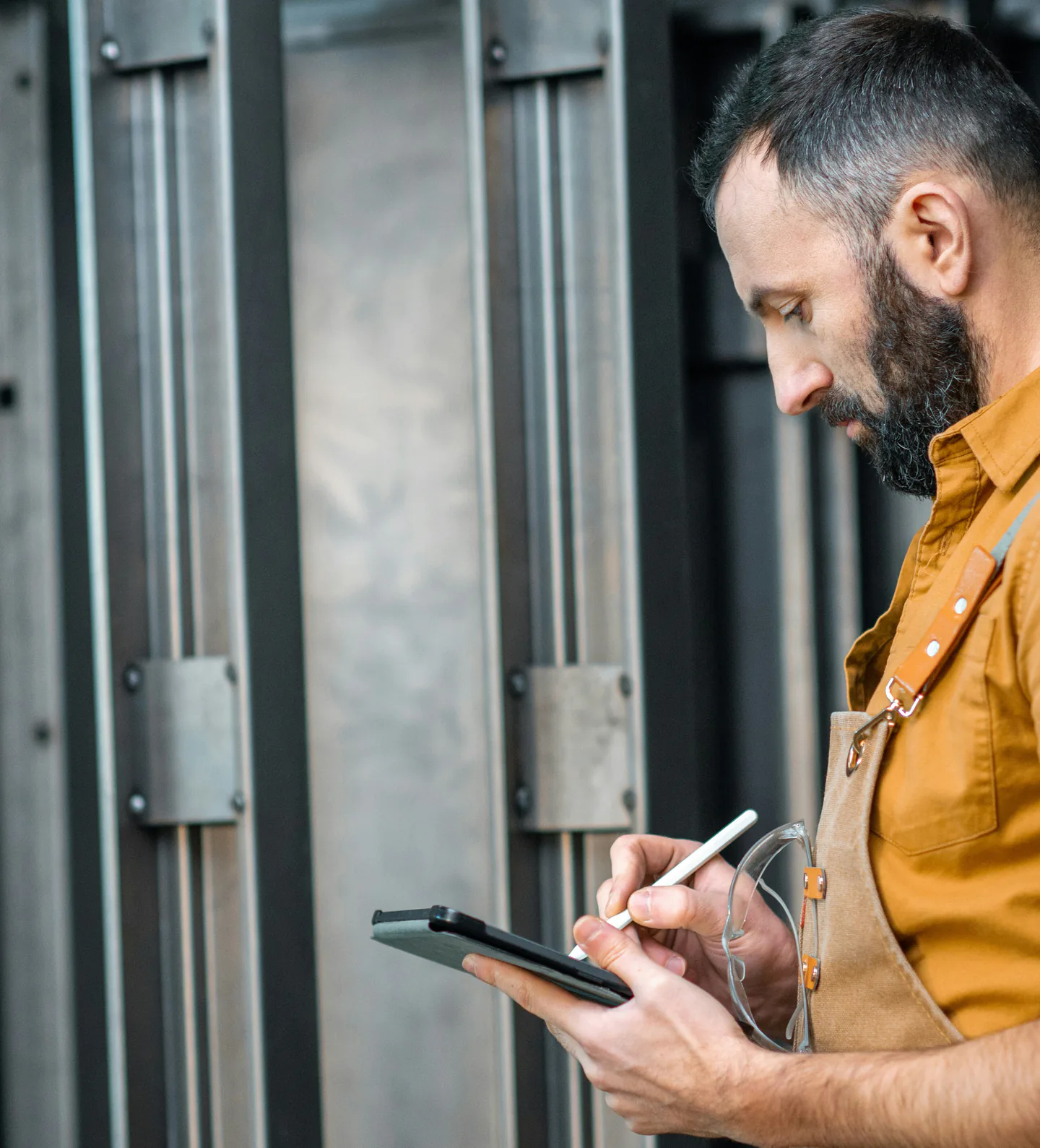 Un technicien saisit une intervention sur sa tablette devant des armoires techniques.