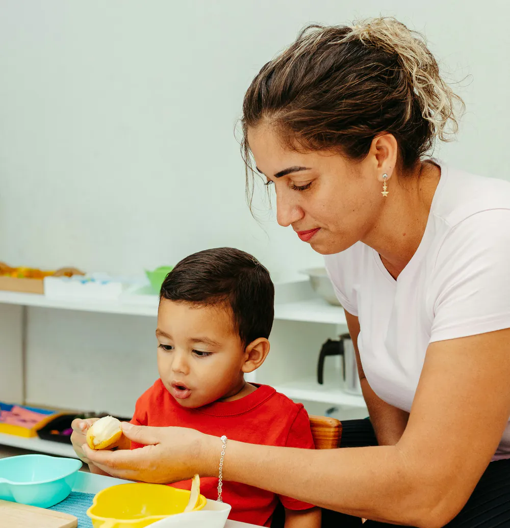 Professionnelle de crèche accompagnant un jeune enfant pendant le repas