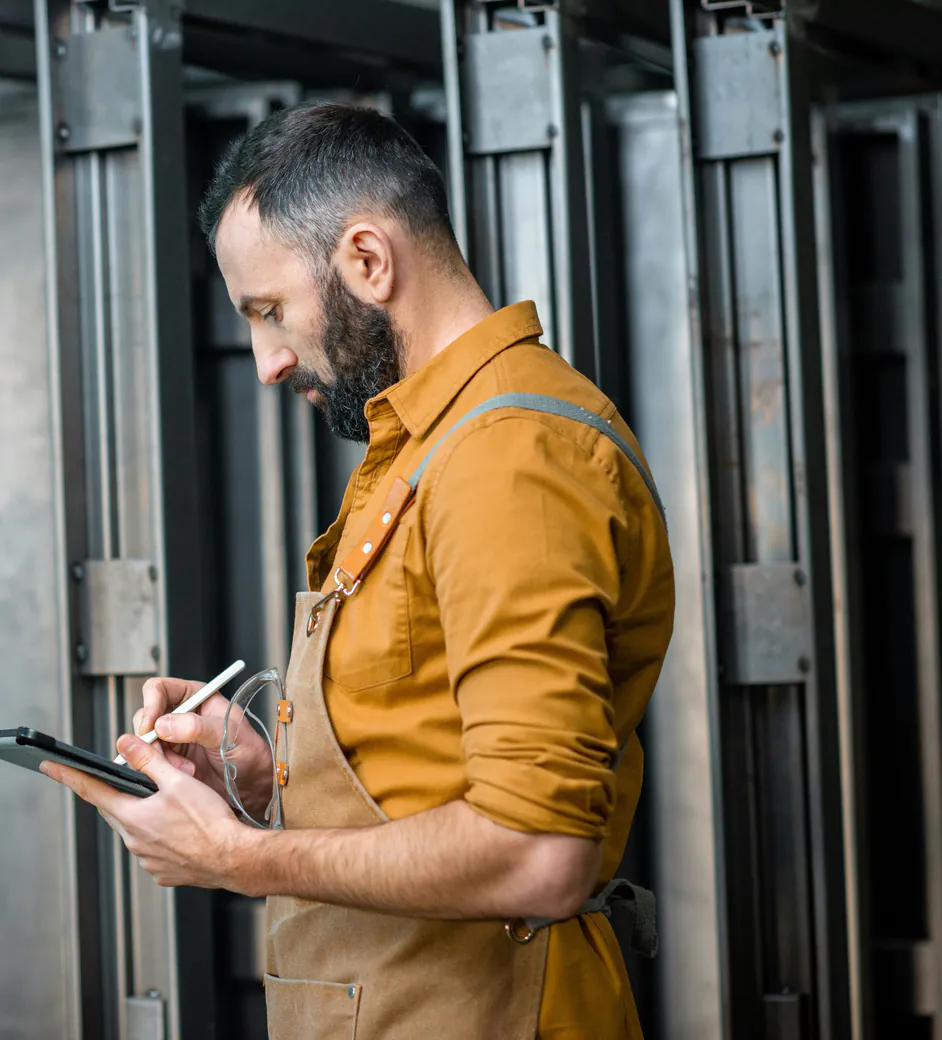 Technicien consultant sa tablette dans un local technique