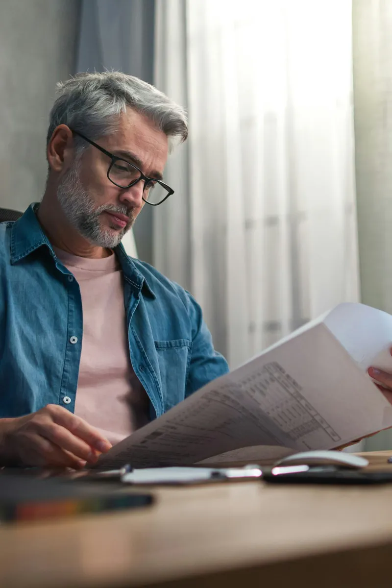 Expert-comptable relisant un tableau financier à son bureau