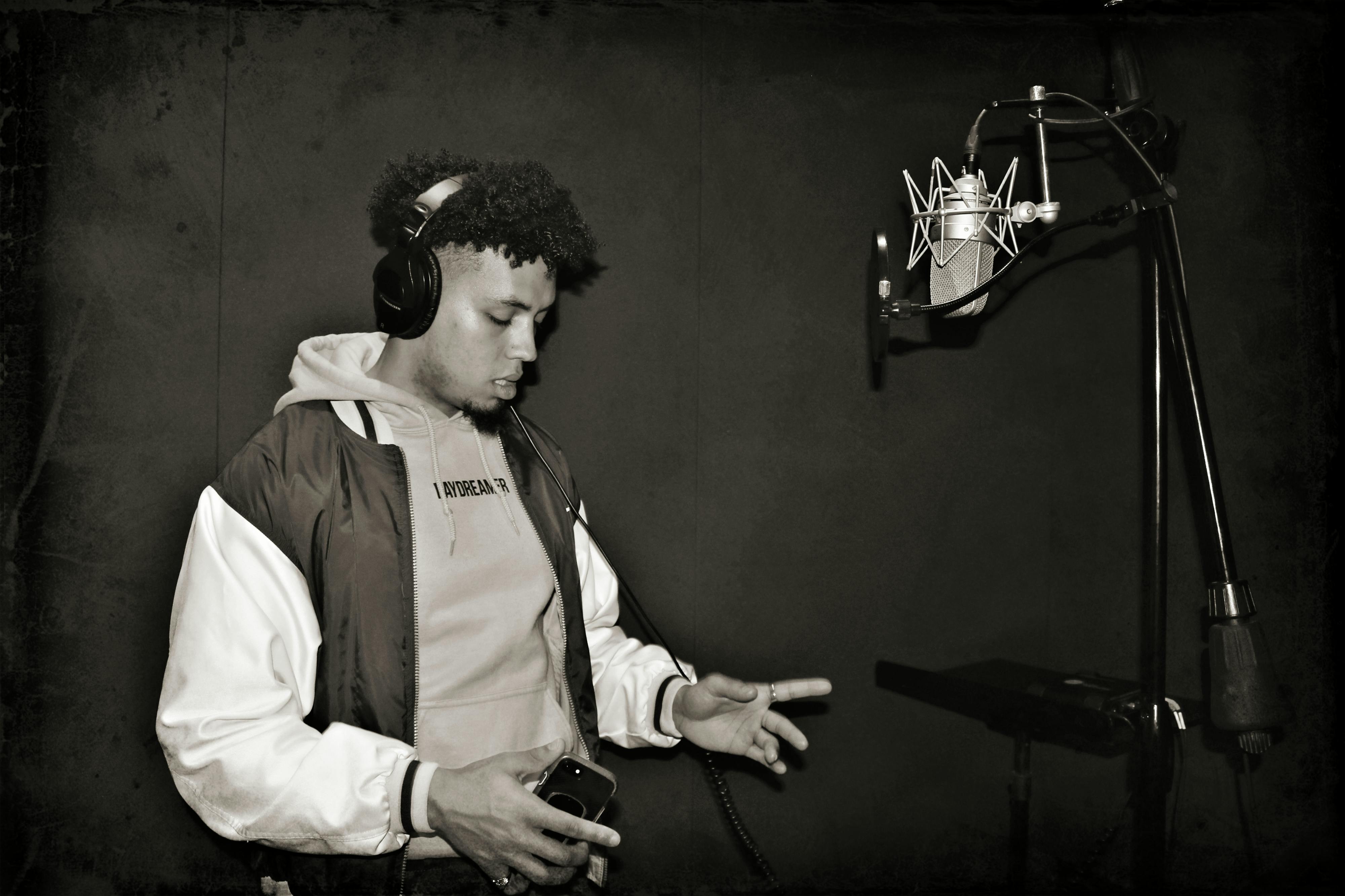 An artist recording in a studio, representing the rapper putting their lyrics and flow to life.