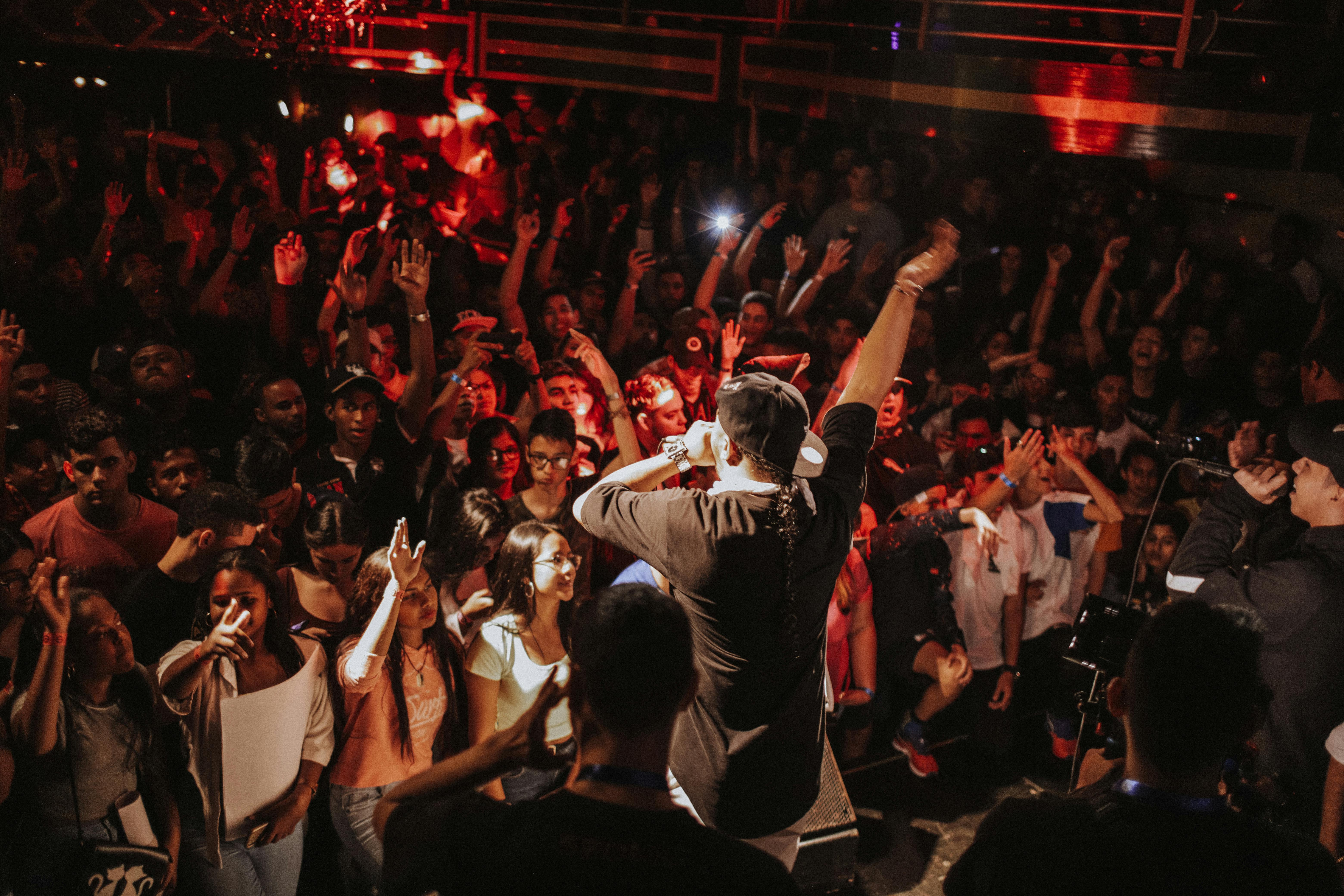 An artist performing in front of a packed house, showcasing trap's huge cultural impact.
