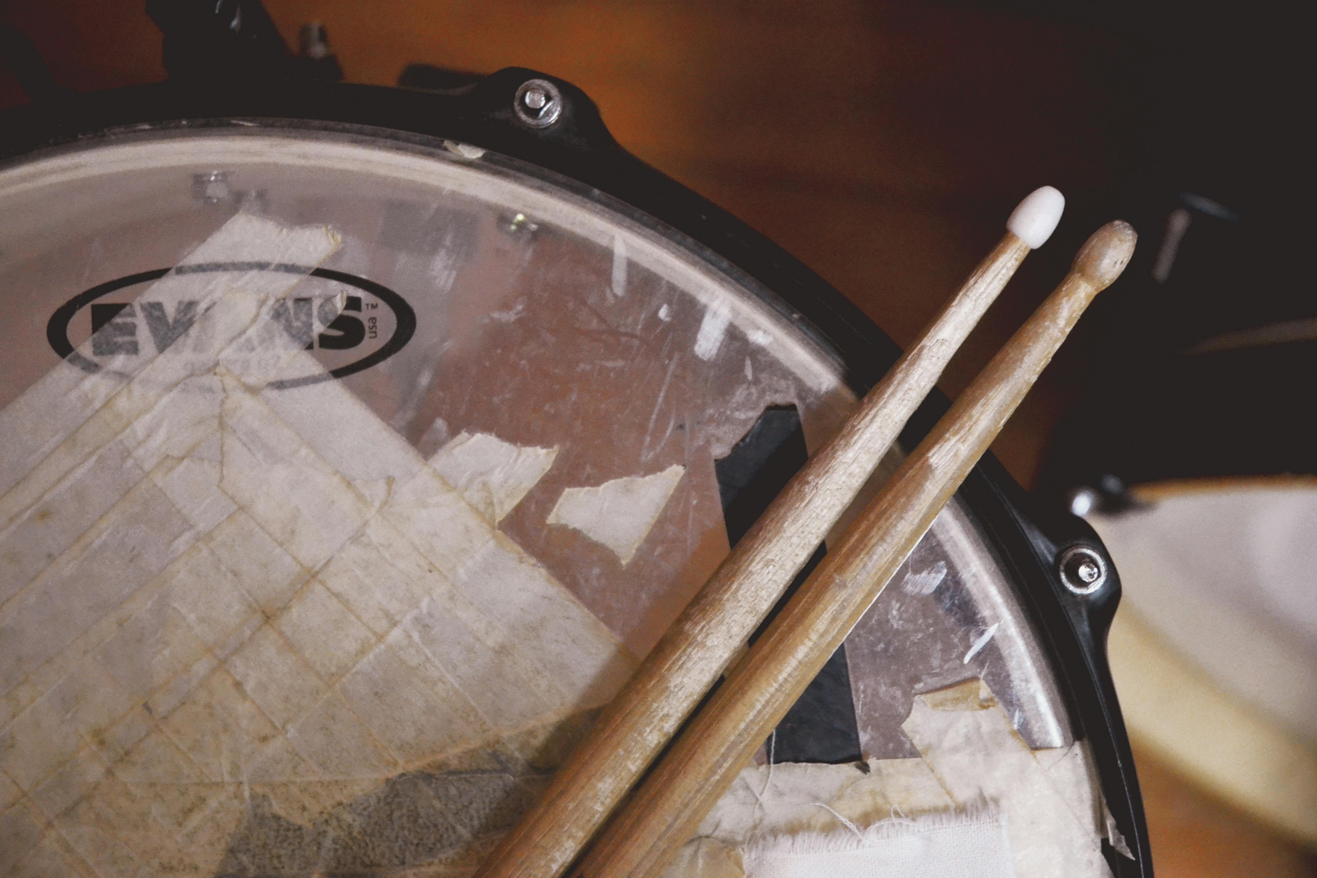 A close-up shot of a well-used drum and drumsticks, representing its importance to rap.