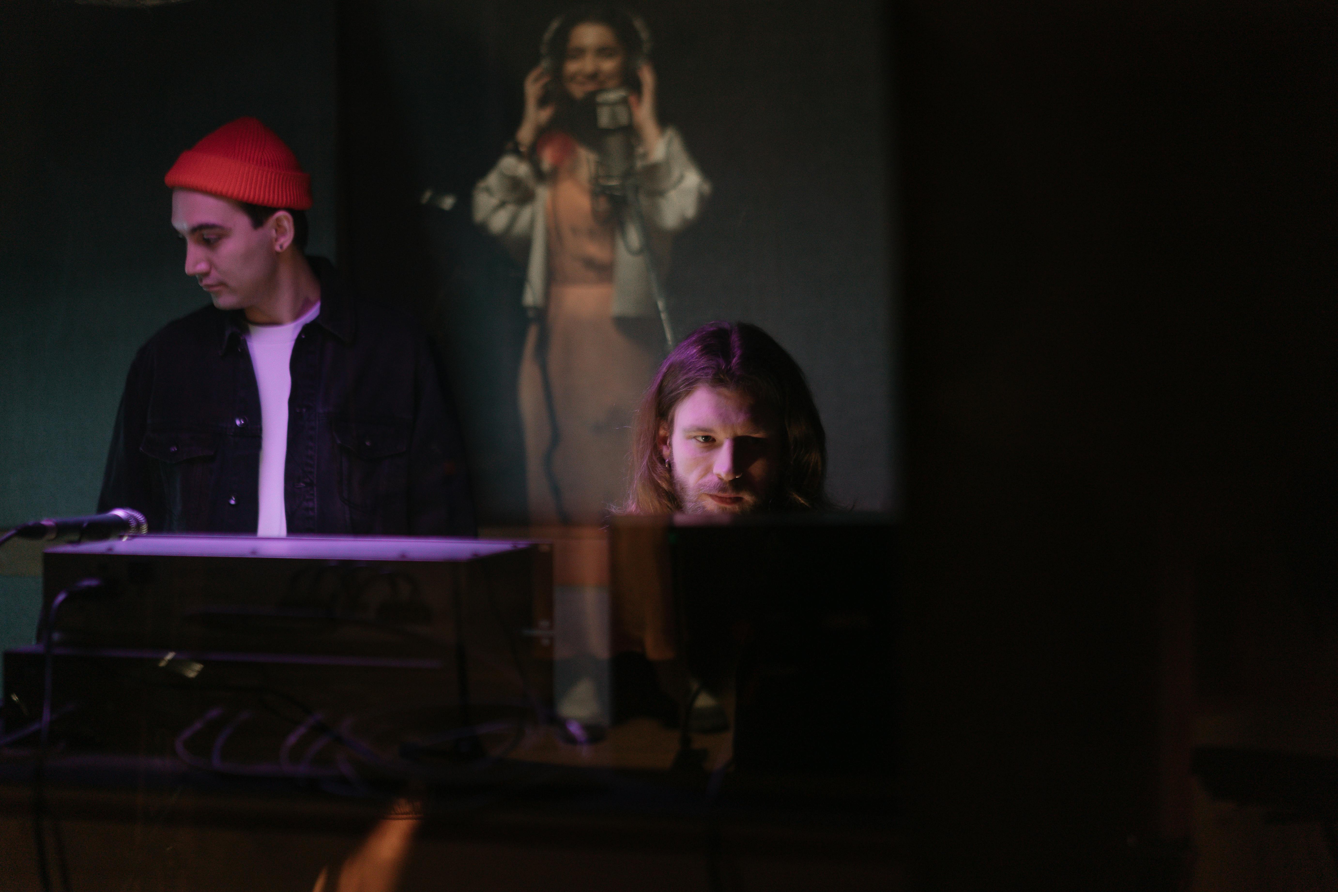 Two artists collaberating. Notably, they're facing away from each other, representing the potential issues that might come up during collaborative efforts.