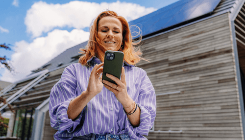 Bewoner bekijkt de energie-app bij een woning met zonnepanelen