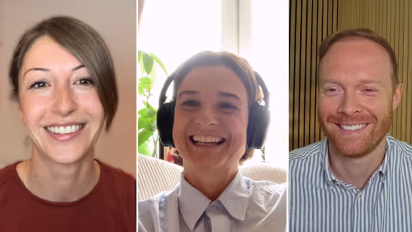Videocall-Screenshot mit drei Personen. In der Mitte Daniela Kielkowski mit Kopfhörern und hellblauer Bluse, sie lacht. Links eine Frau mit braunem Shirt, rechts ein Mann mit rotblondem Bart und gestreiftem Hemd. Alle drei schauen freundlich in die Kamera.