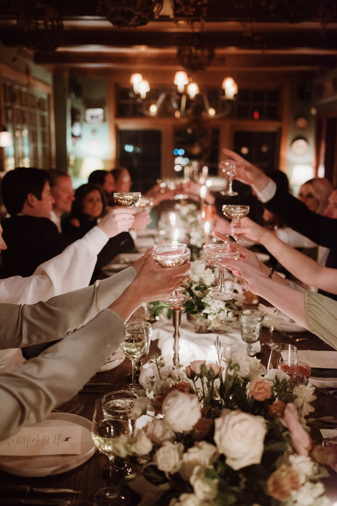 Guests toasting over a candlelit table with roses at Deer Mountain Inn