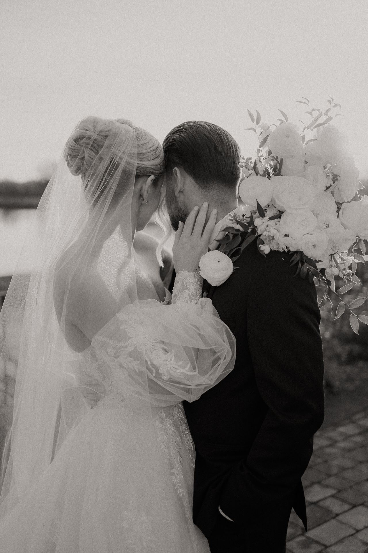 Black and white photograph of a bride and groom kissing beneath her veil at Glen Sanders Mansion