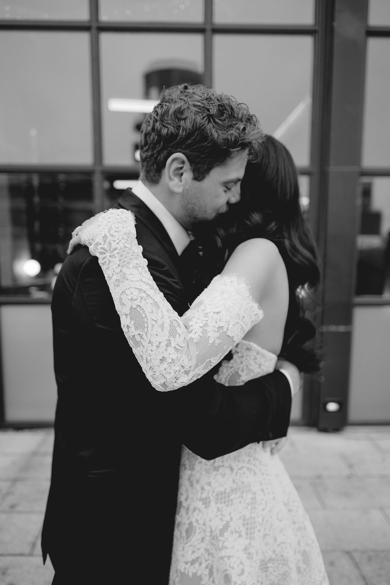 Black and white photograph of a couple embracing outside the Wythe Hotel in Brooklyn