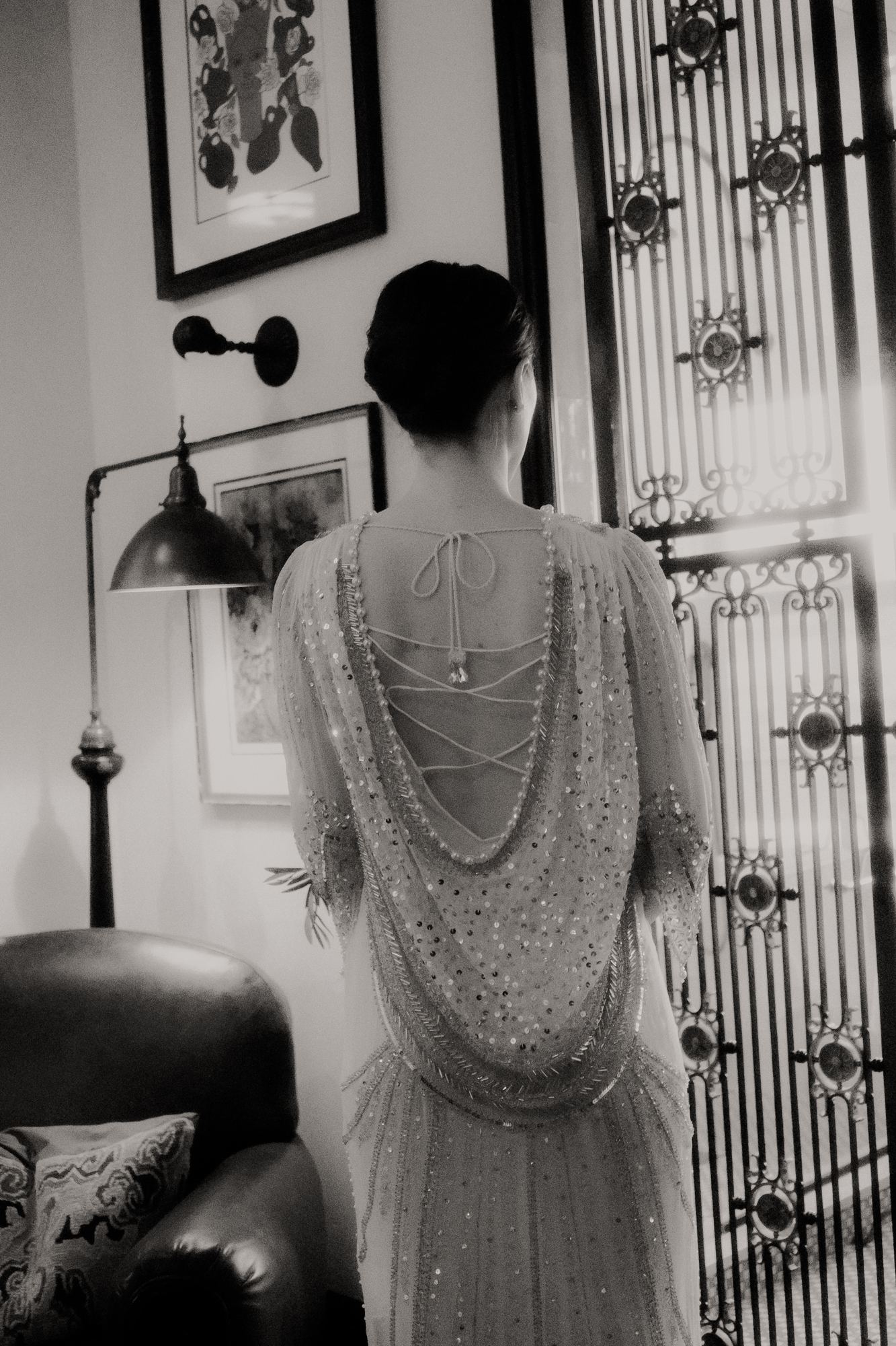 Bride photographed from behind in a beaded gown before the ceremony